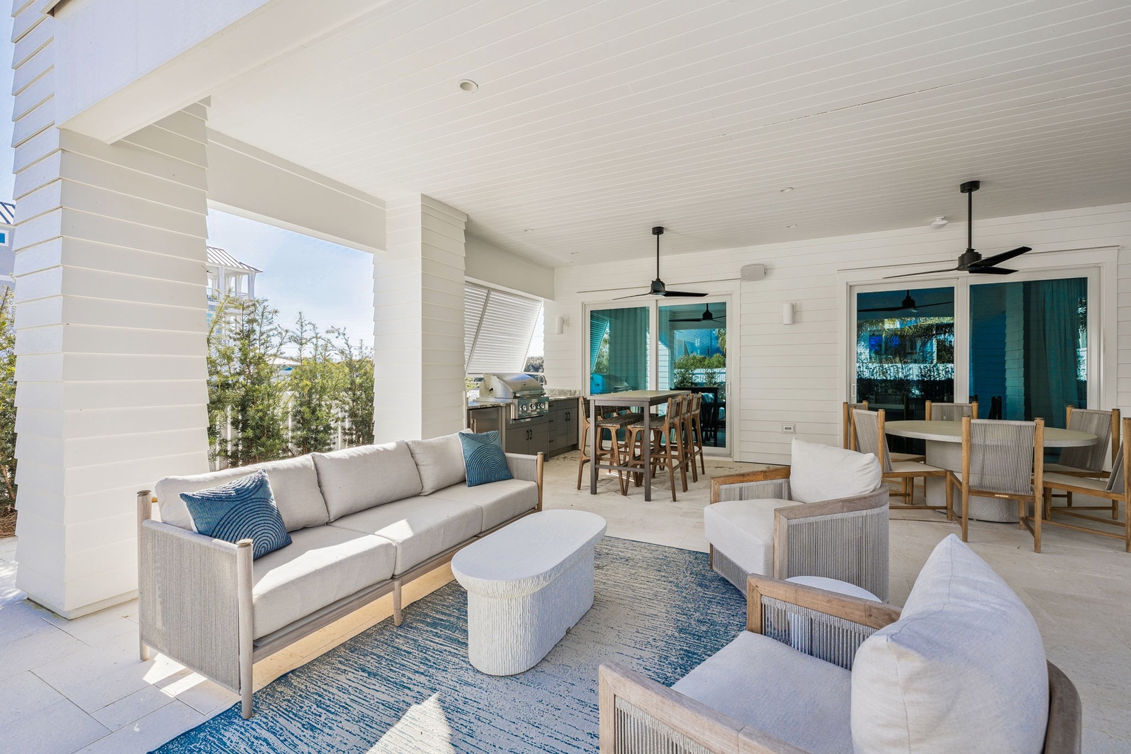 Relax in your covered patio oasis with comfortable seating, outdoor kitchen, and ceiling fans for perfect tropical comfort.