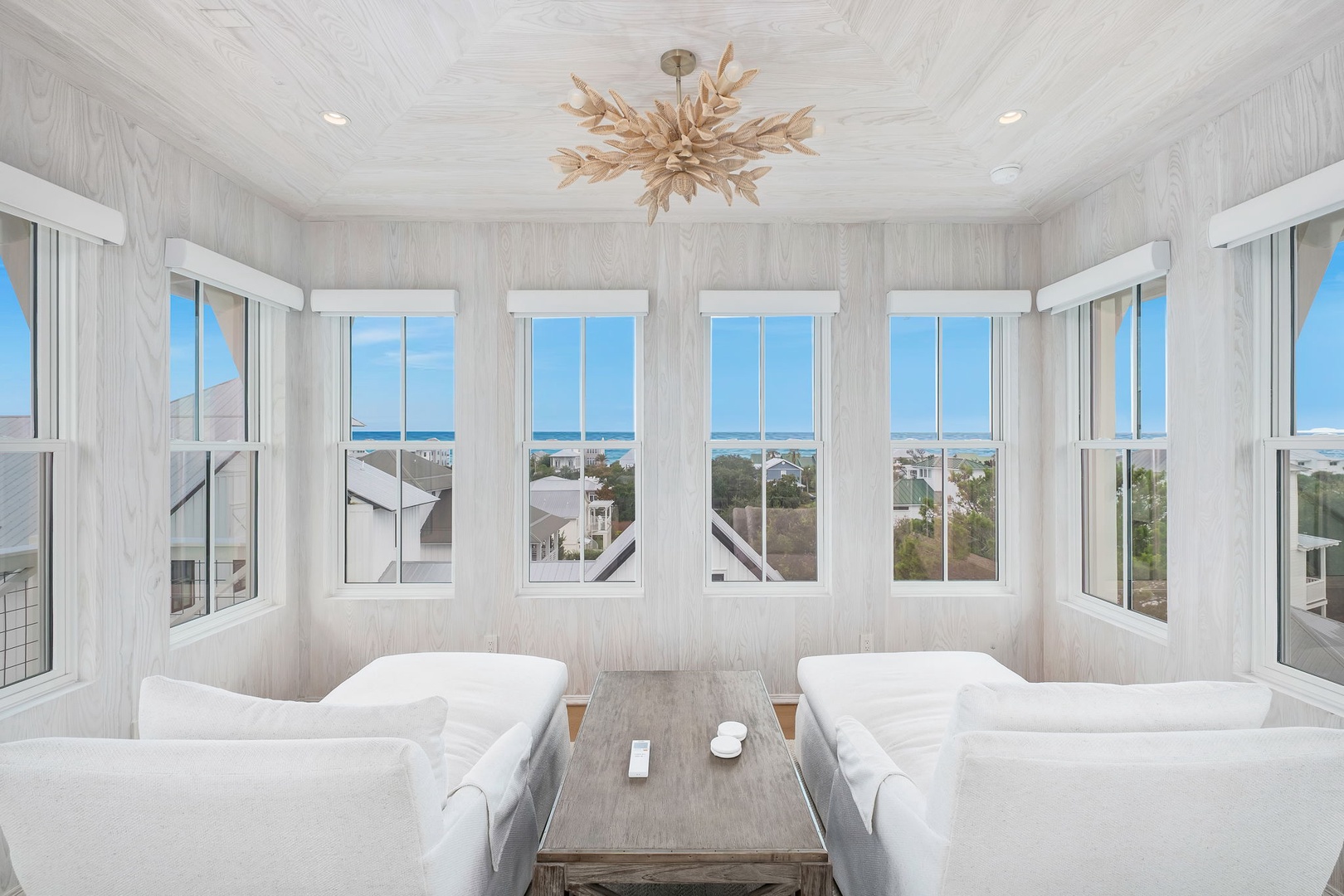Settle into your elegant living space surrounded by windows that frame stunning ocean views—a perfect spot to unwind and savor the coastal beauty from every angle.