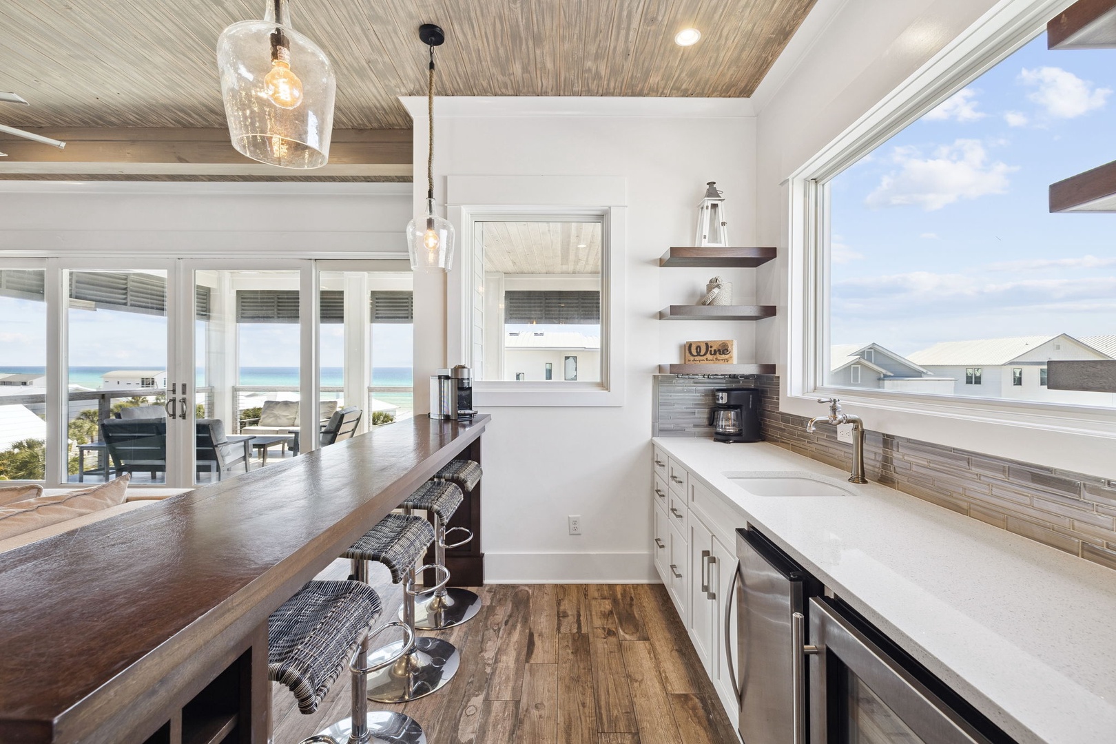 Your gourmet kitchen flows seamlessly to ocean views, where morning coffee meets endless blue horizons through floor-to-ceiling windows.