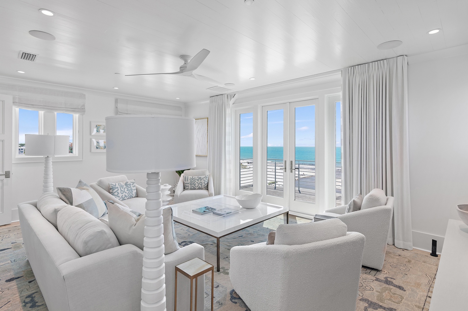 Relax in this bright, airy living space where soft textures meet coastal calm. French doors frame stunning sea views, while plush seating invites you to unwind. Step outside to your private deck and breathe in the ocean breeze.