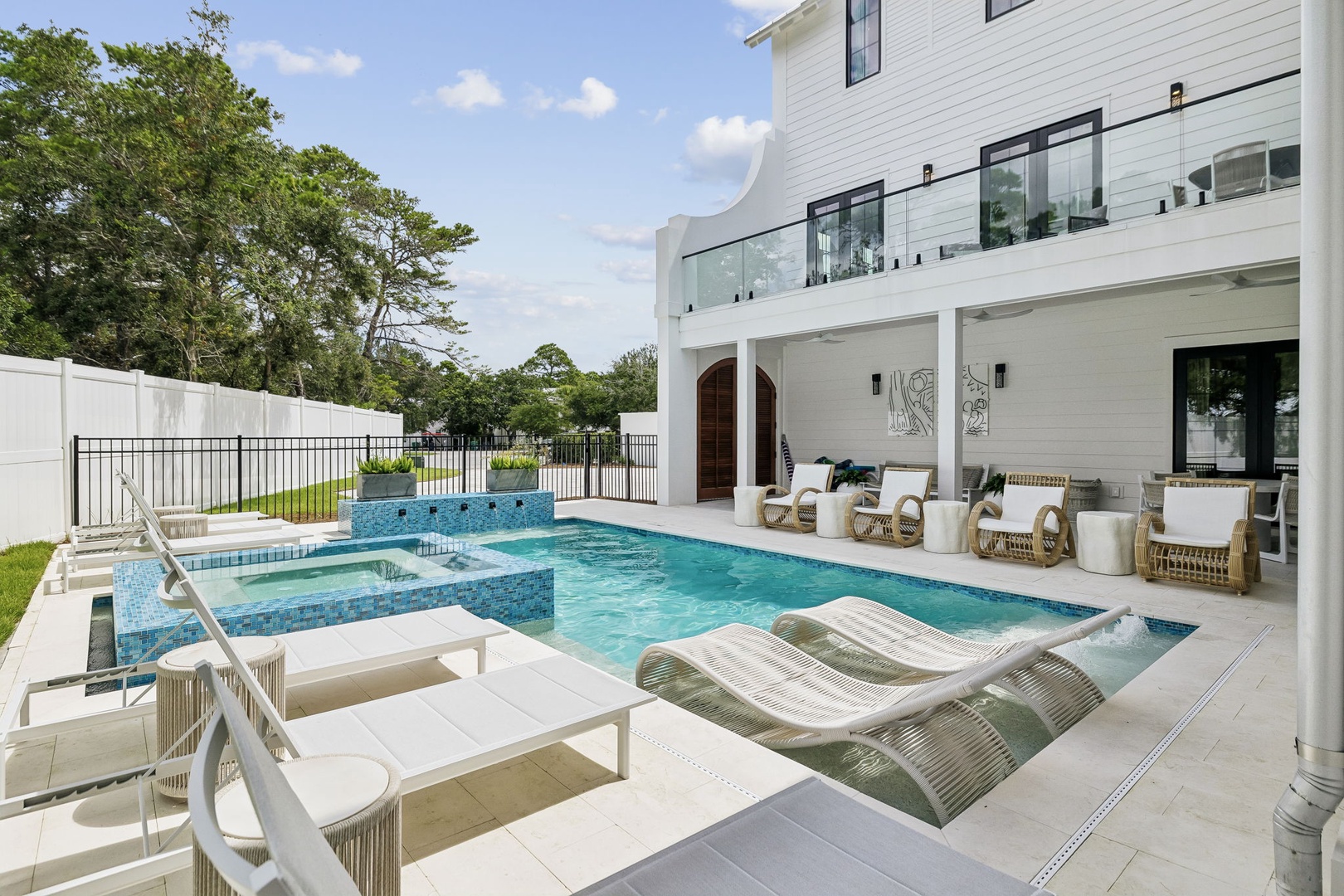 Modern coastal elegance frames your private oasis, where sun-soaked loungers invite lazy afternoons beside pristine turquoise waters and a cascading hot tub awaits under open skies.
