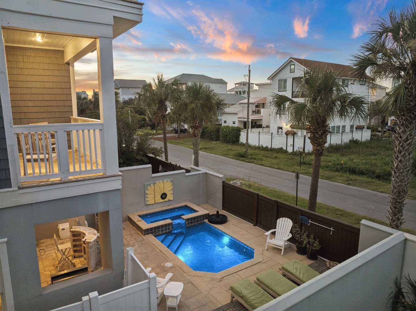 A coastal retreat where twilight paints the sky while your private pool beckons below. The view stretches over neighboring palm trees and homes toward the horizon, perfectly framed from your upstairs balcony as the day gently transitions to evening.