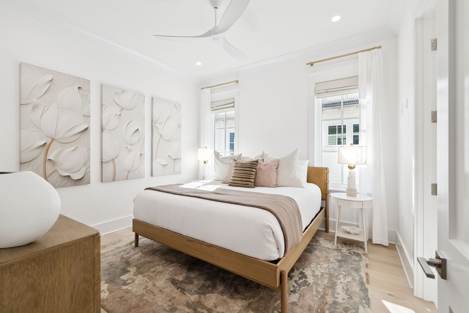 Drift into peaceful sleep in your elegant bedroom, where soft white linens meet warm wood tones and gentle natural light streams through oversized windows.