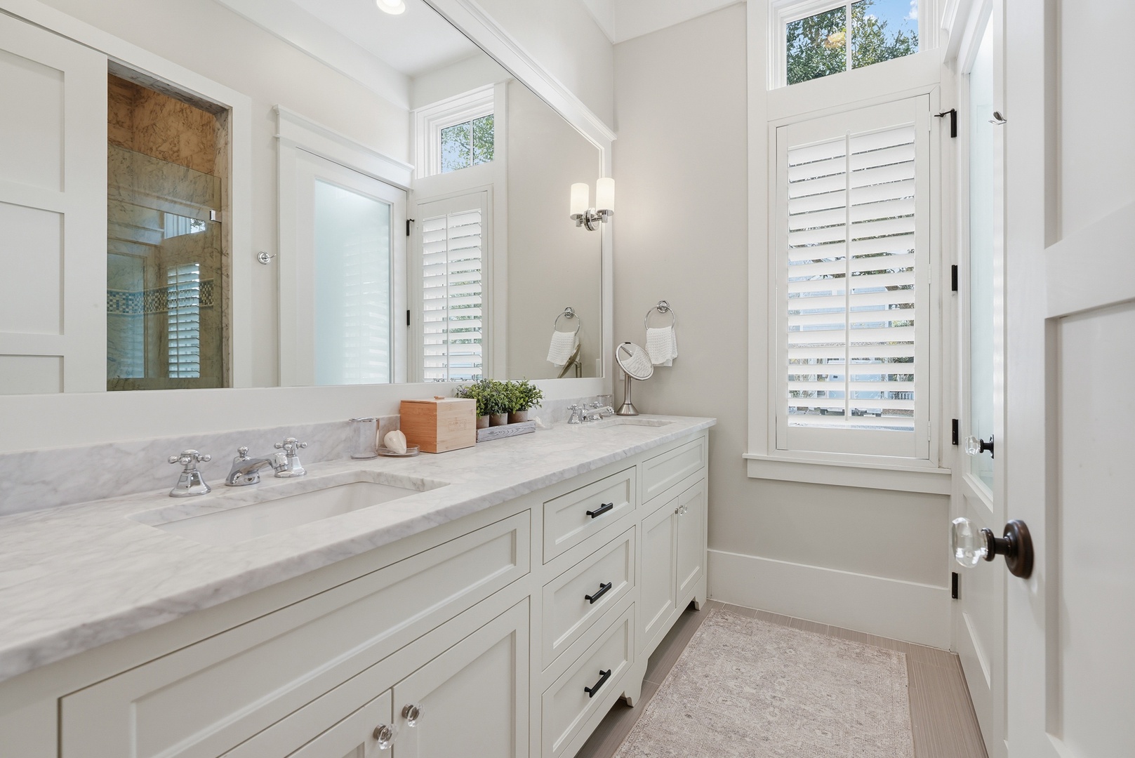 Refresh in this elegant bathroom with dual marble vanities, bright natural light, and tasteful finishes that make every morning feel like a spa retreat.