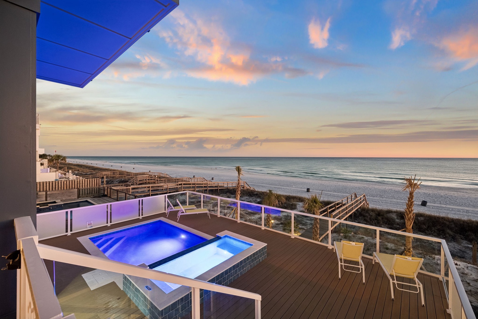 Breathtaking beachfront terrace featuring private hot tub with stunning sunset views over pristine coastline.