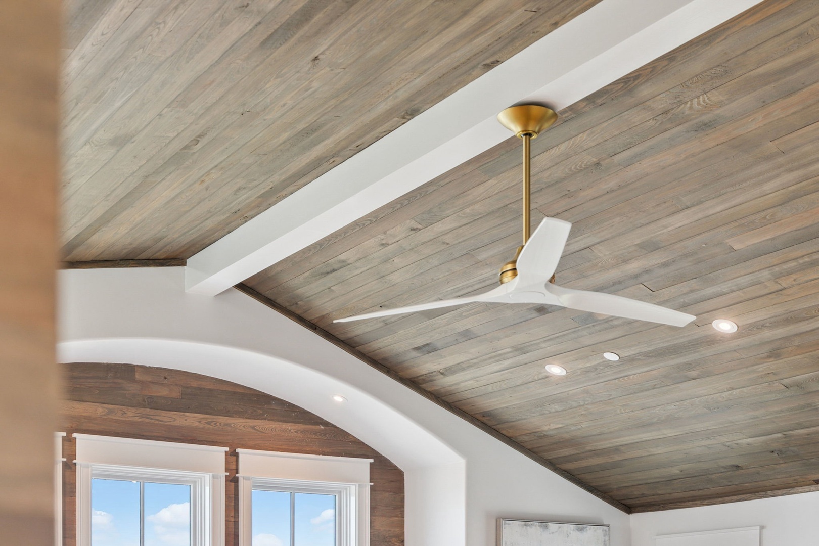 Stunning weathered wood ceiling beams create a warm, rustic ambiance above, while modern lighting and a sleek ceiling fan keep your space comfortable year-round.