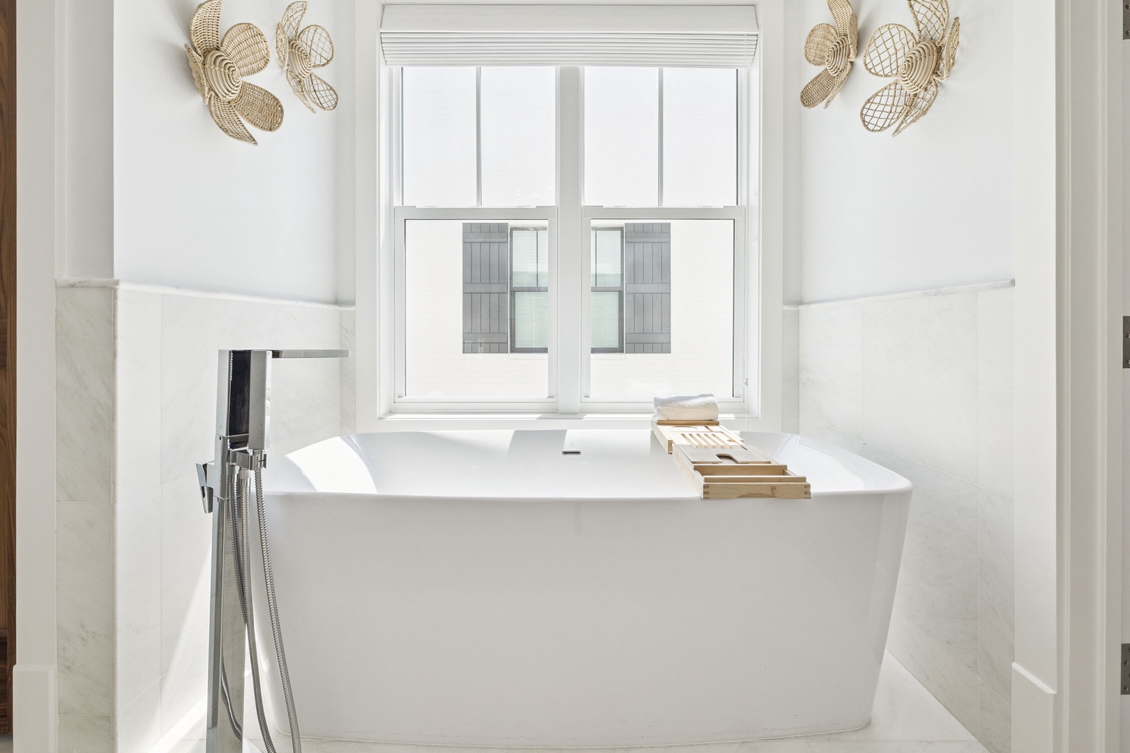 Slip into your private sanctuary with this elegant soaking tub, where natural light and coastal charm create the perfect escape.