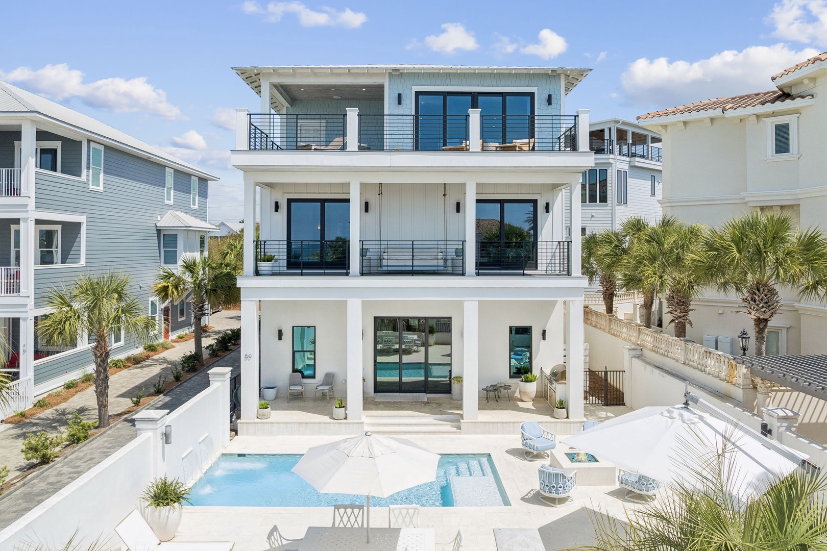 Modern beachside villa featuring multiple levels of luxury with private pool and tropical landscaping in an upscale coastal neighborhood.