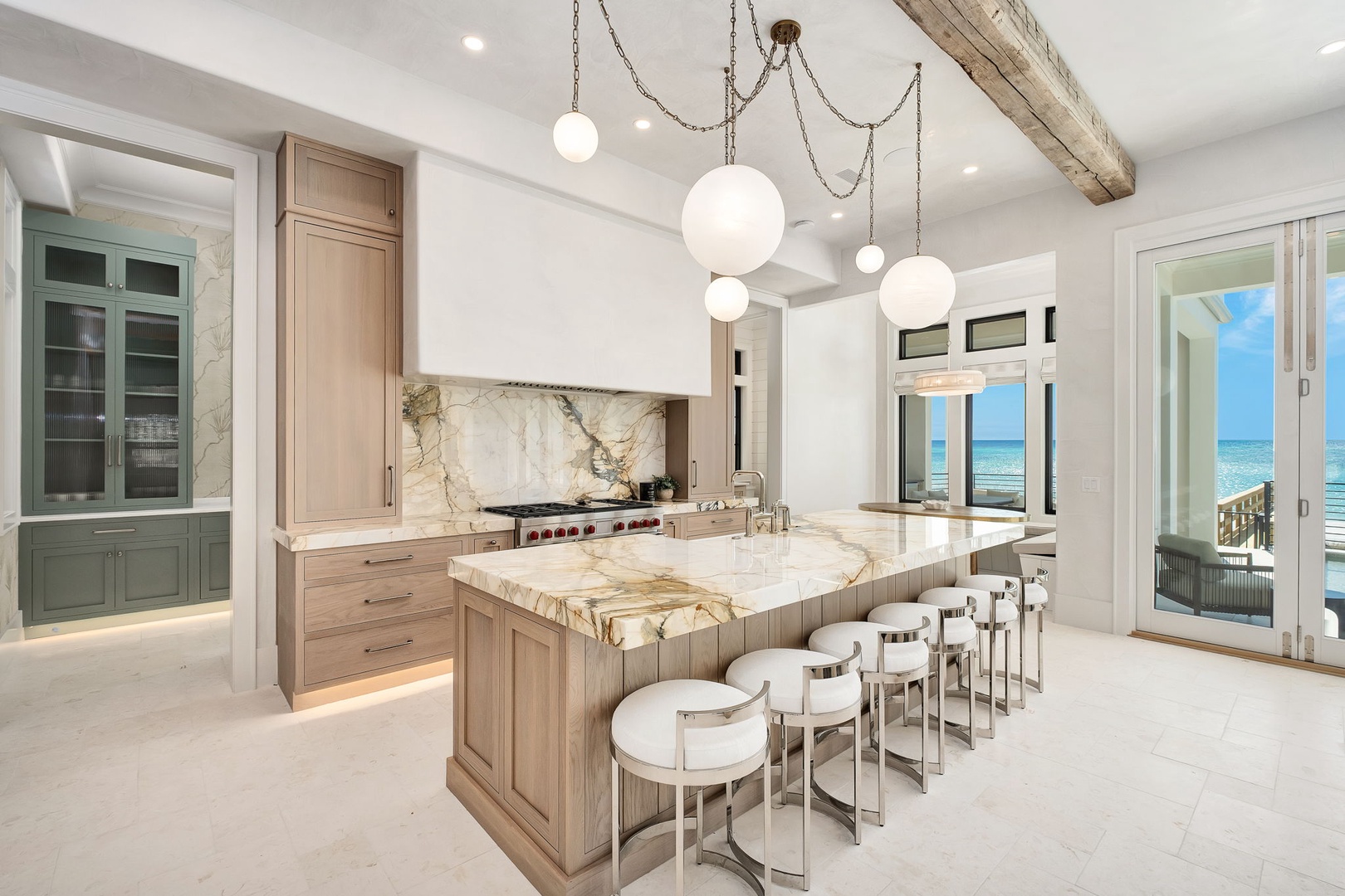 Your gourmet kitchen blends luxury marble with warm wood tones, featuring ocean views that transform cooking into pure inspiration.