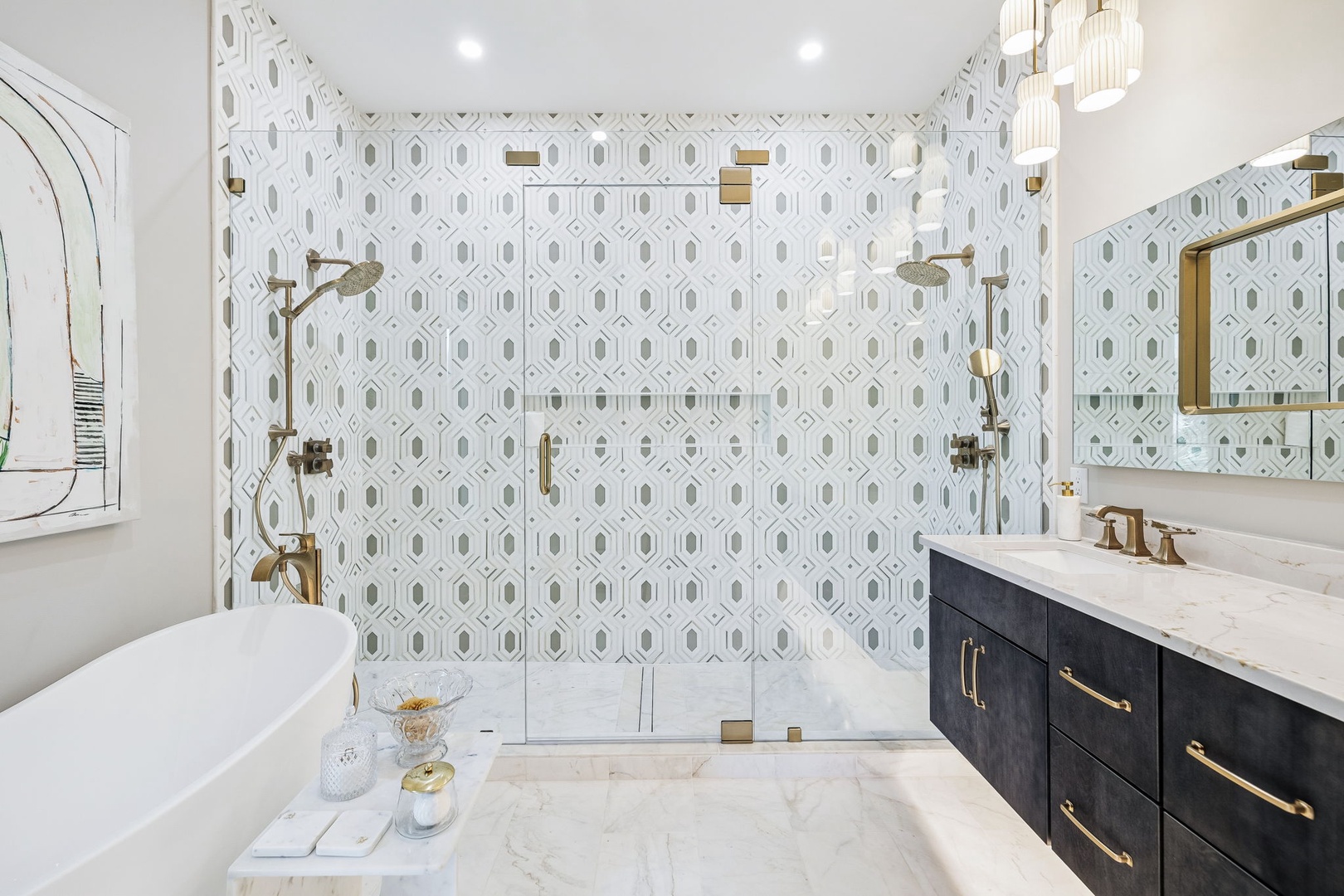 Luxurious bathroom featuring a freestanding soaking tub, elegant tiled walk-in shower with dual fixtures, marble floors, and stylish brass accents throughout—perfect for unwinding after your adventures.