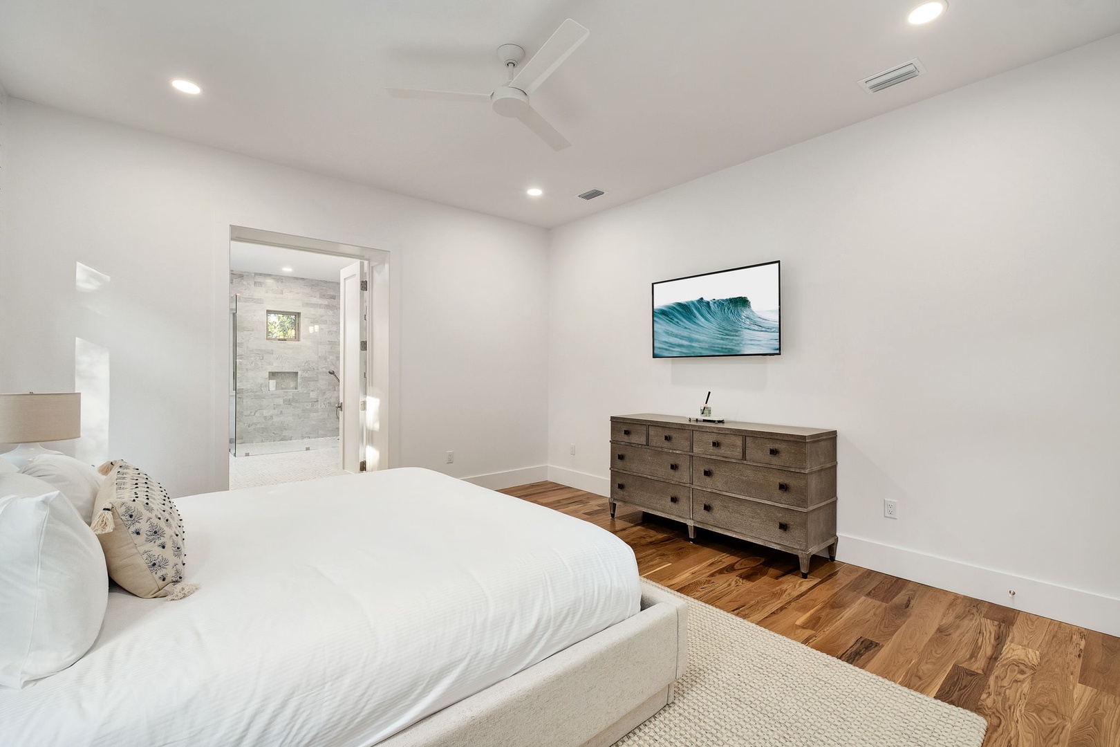 Drift into peaceful sleep in your serene master suite with warm hardwood floors, elegant furnishings, and stunning en-suite shower awaiting.