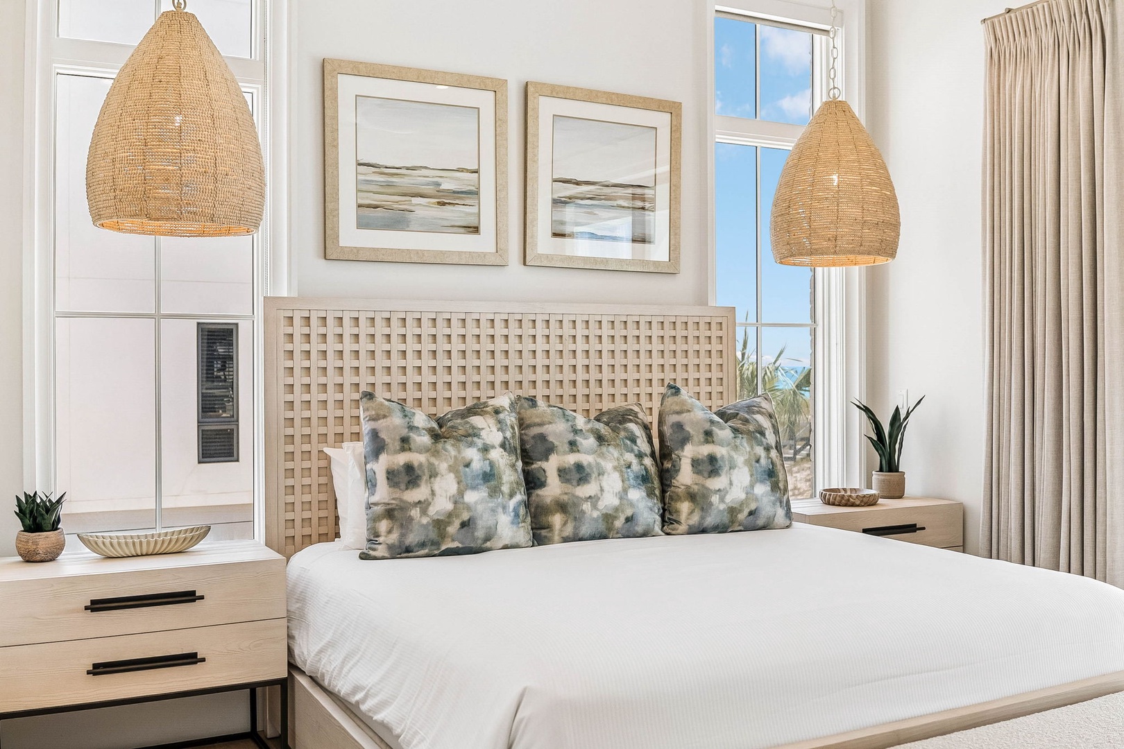 Your serene coastal-inspired bedroom invites you to unwind under woven pendant lights, with crisp white linens and soft textured pillows ready to cradle you after a day of adventure.