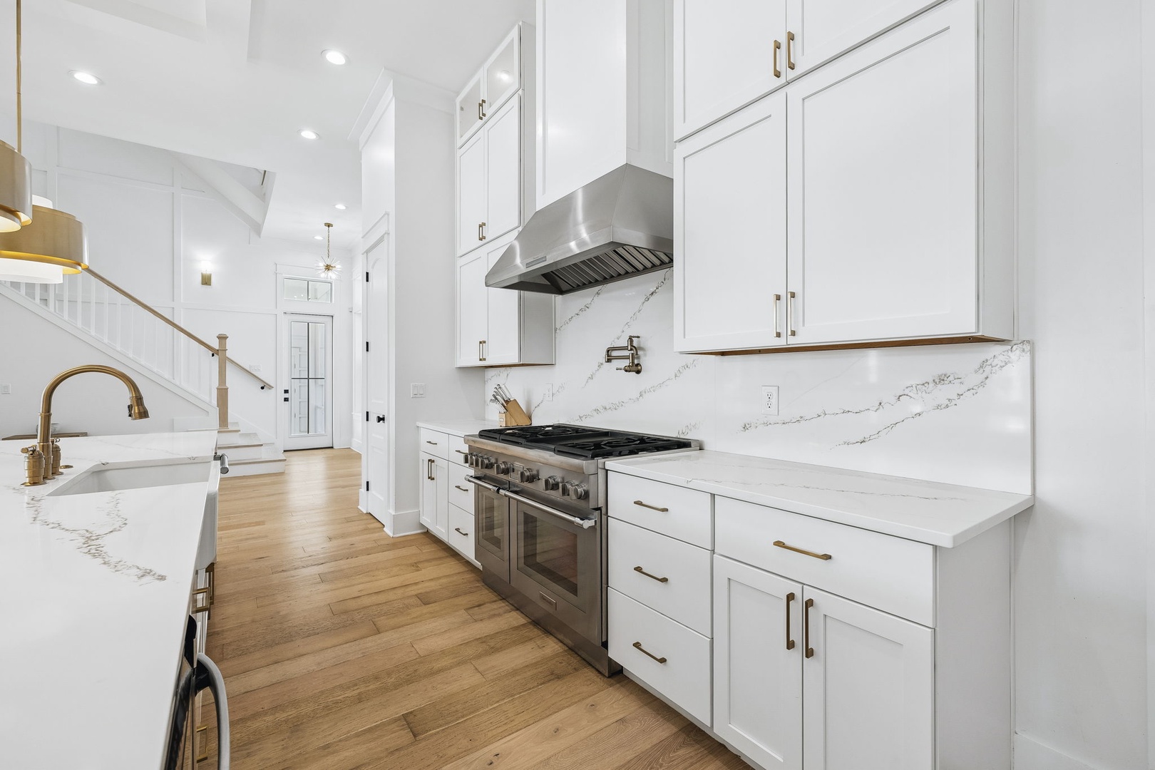 Bright, pristine kitchen with sleek white cabinetry, elegant marble countertops, and professional-grade stainless steel appliances ready for you to create your favorite meals.