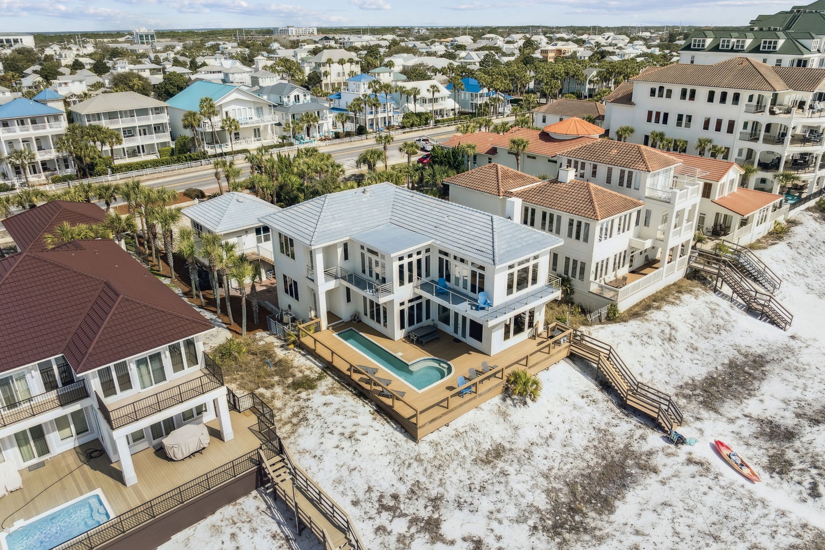Luxurious beachfront property with private pool and deck, nestled among coastal homes with beach access just steps away.