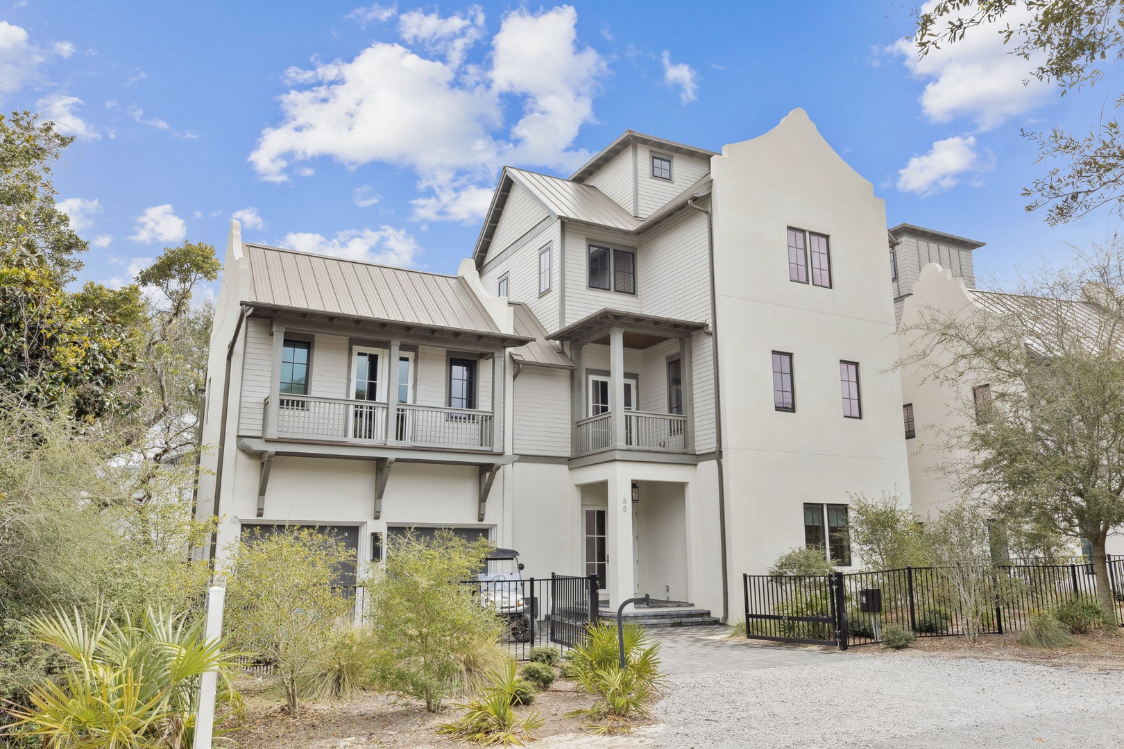 Modern coastal architecture nestled among native landscaping creates an impressive arrival experience at this distinctive property.