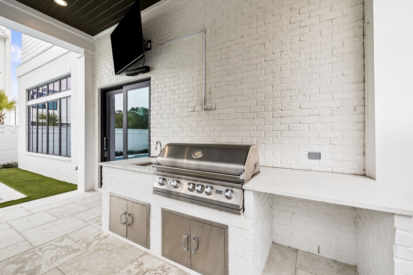 Fire up your culinary skills at this sleek outdoor kitchen with premium stainless steel grill and marble countertops.