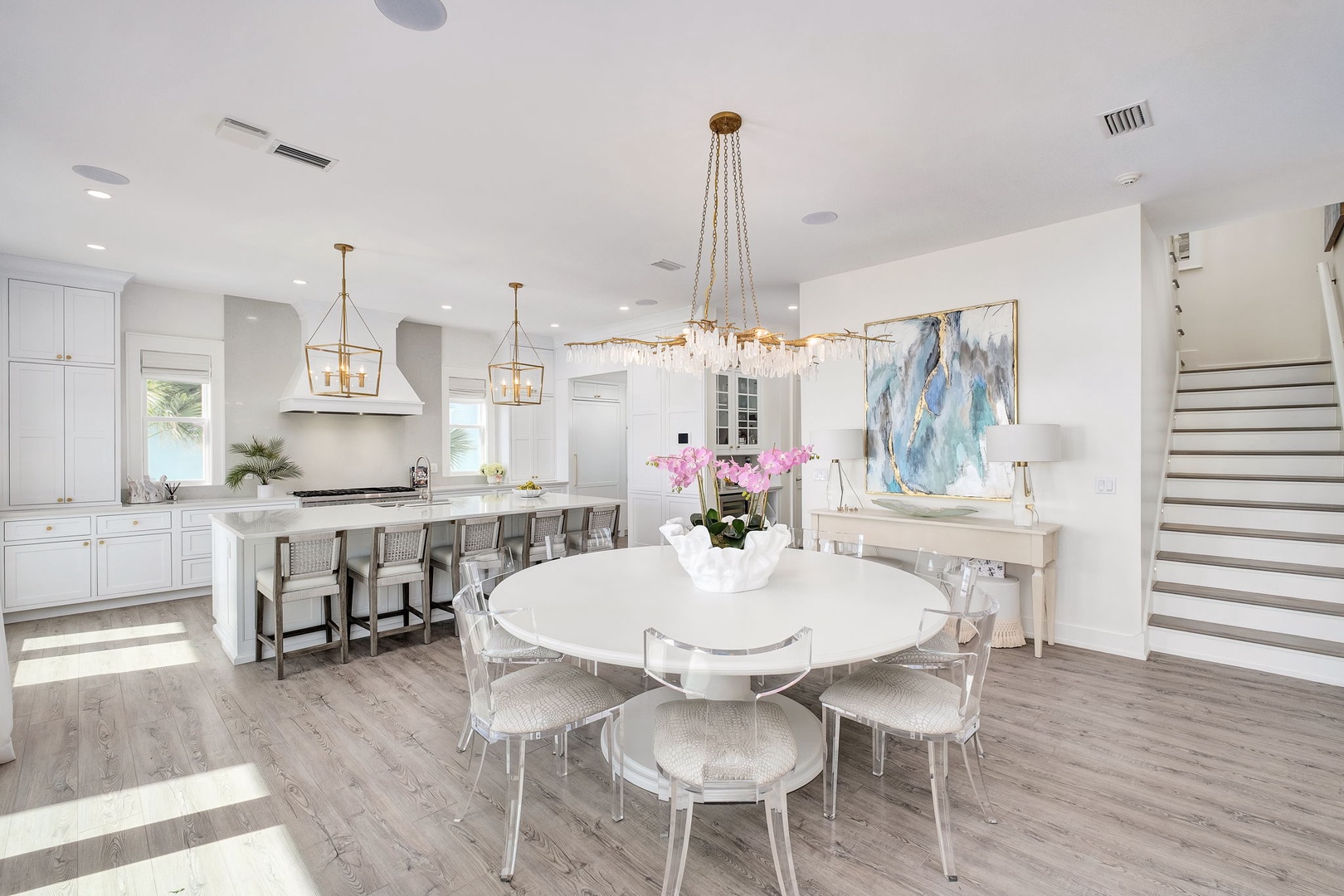 Gather around the elegant dining table under a stunning chandelier, then move to the spacious kitchen island for casual meals and conversation.