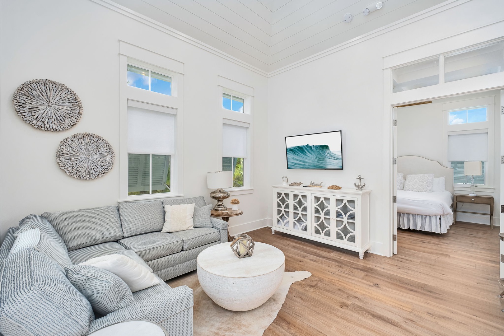 Unwind in this bright, coastal-inspired living space where soft neutrals and ocean-themed accents create your serene escape. Sink into the plush sectional and let the airy ceilings and natural light wash over you.