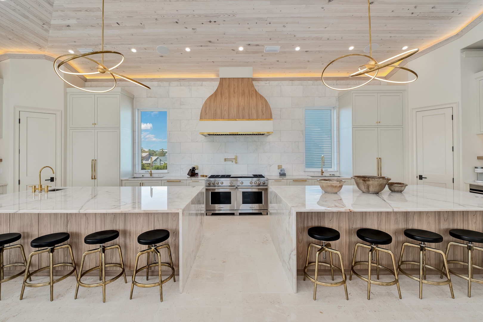 Picture yourself preparing meals in this stunning gourmet kitchen, featuring gleaming marble countertops, professional-grade appliances, and elegant gold fixtures. Gather your group at the double islands with seating for eight.
