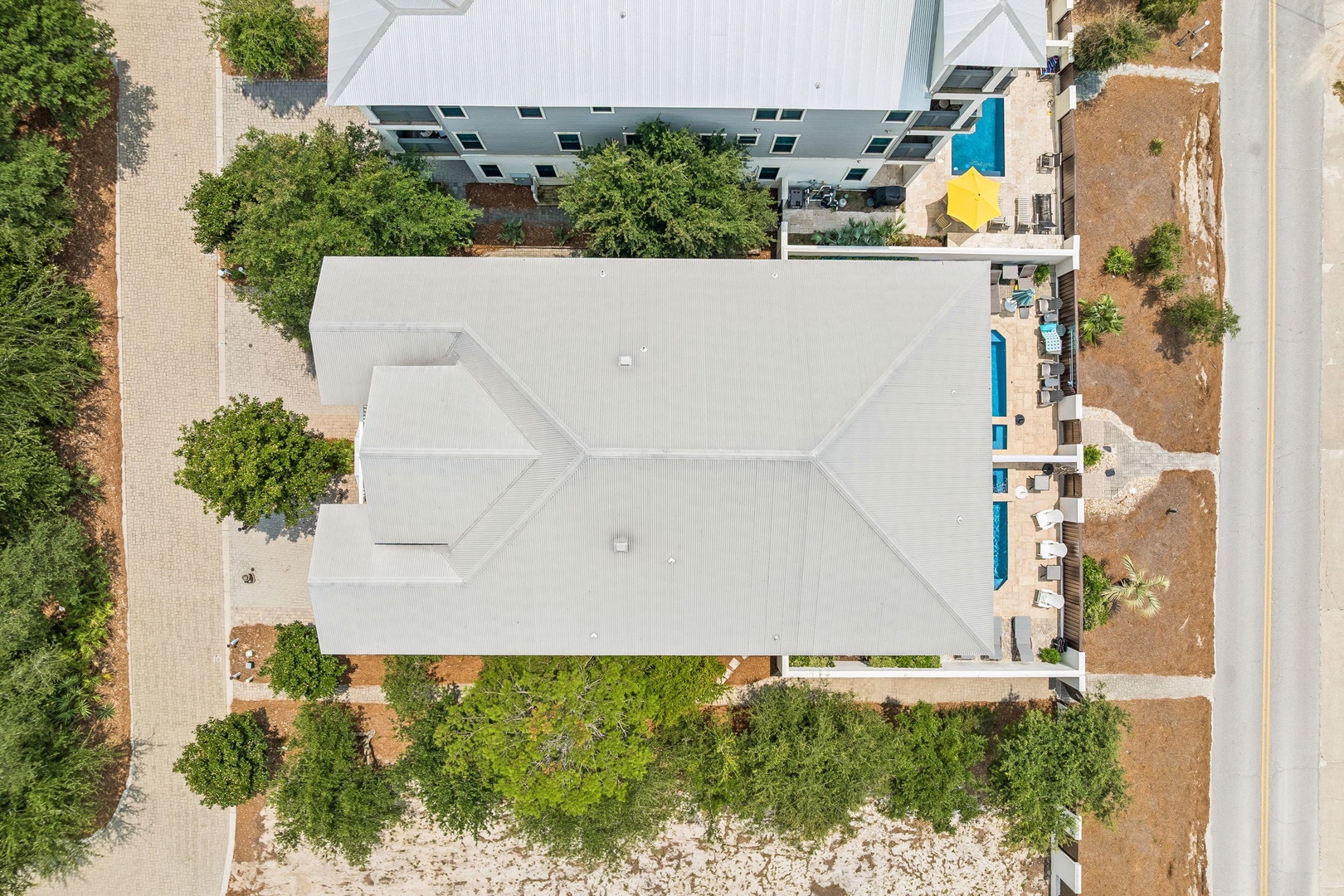 An aerial view capturing the property layout, featuring modern architecture, a sparkling pool, and landscaped surroundings nestled in a peaceful neighborhood.