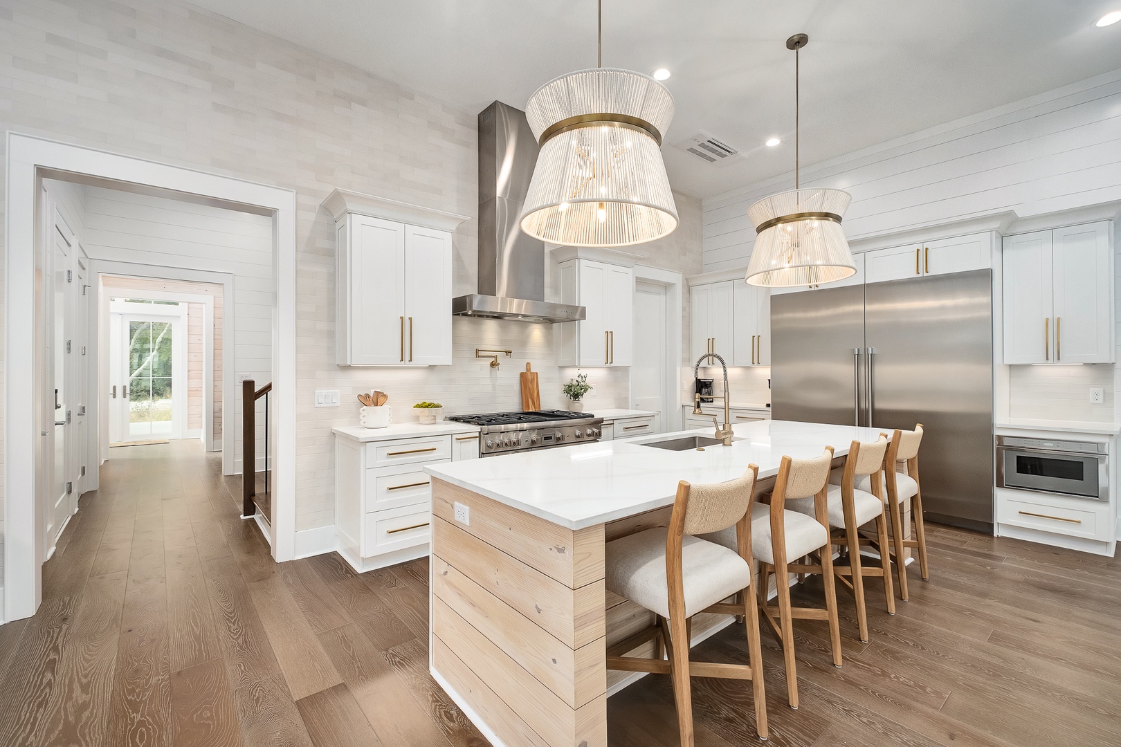 Your chef-worthy kitchen awaits with pristine white cabinetry, professional appliances, and a stunning island perfect for morning coffee or evening gatherings.
