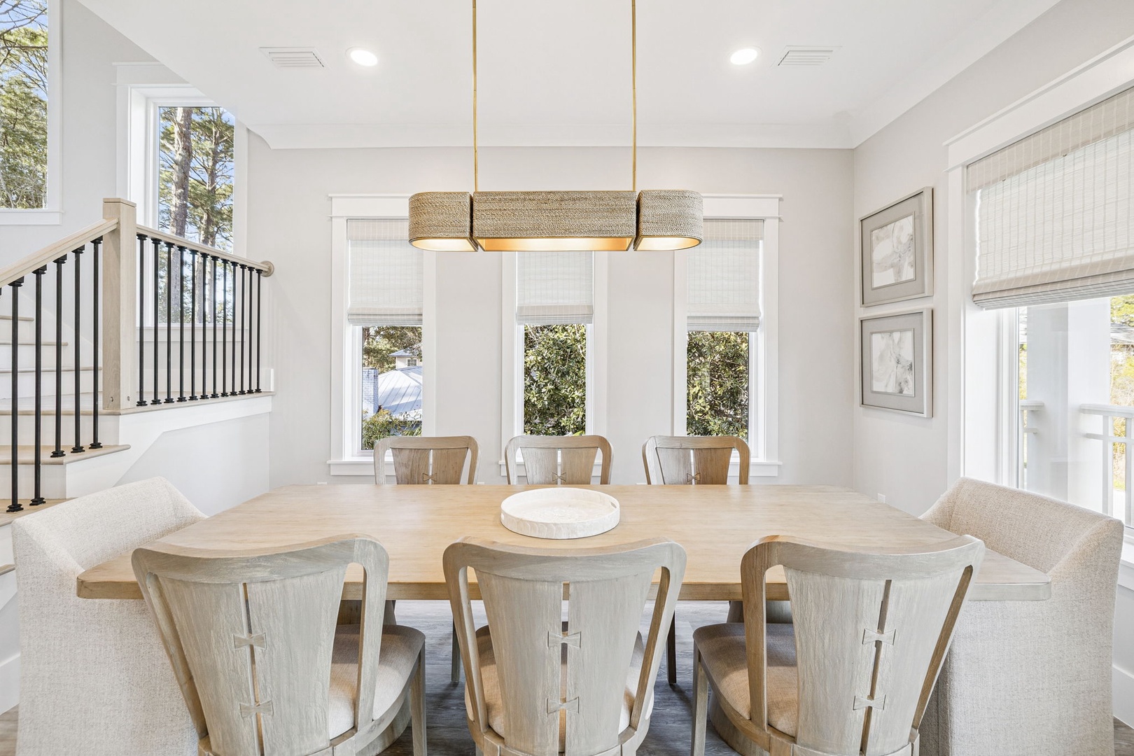 Gather around this stunning dining table where natural light streams through expansive windows, creating the perfect setting for your memorable meals together.