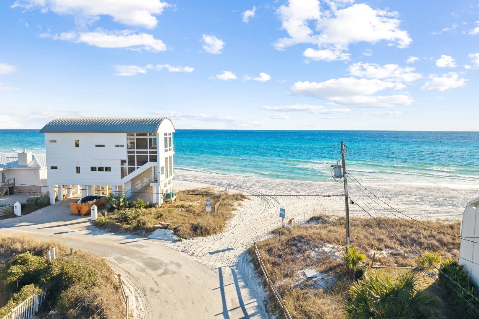 Modern beachfront property sits steps from pristine white sand and turquoise waters along the Gulf Coast.
