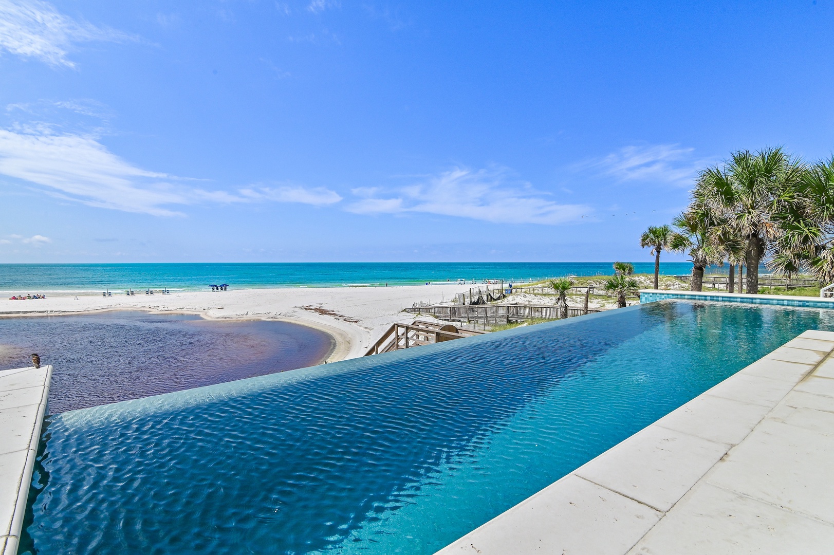 An infinity pool meets turquoise waves and white sand—your slice of coastal paradise awaits just steps away.