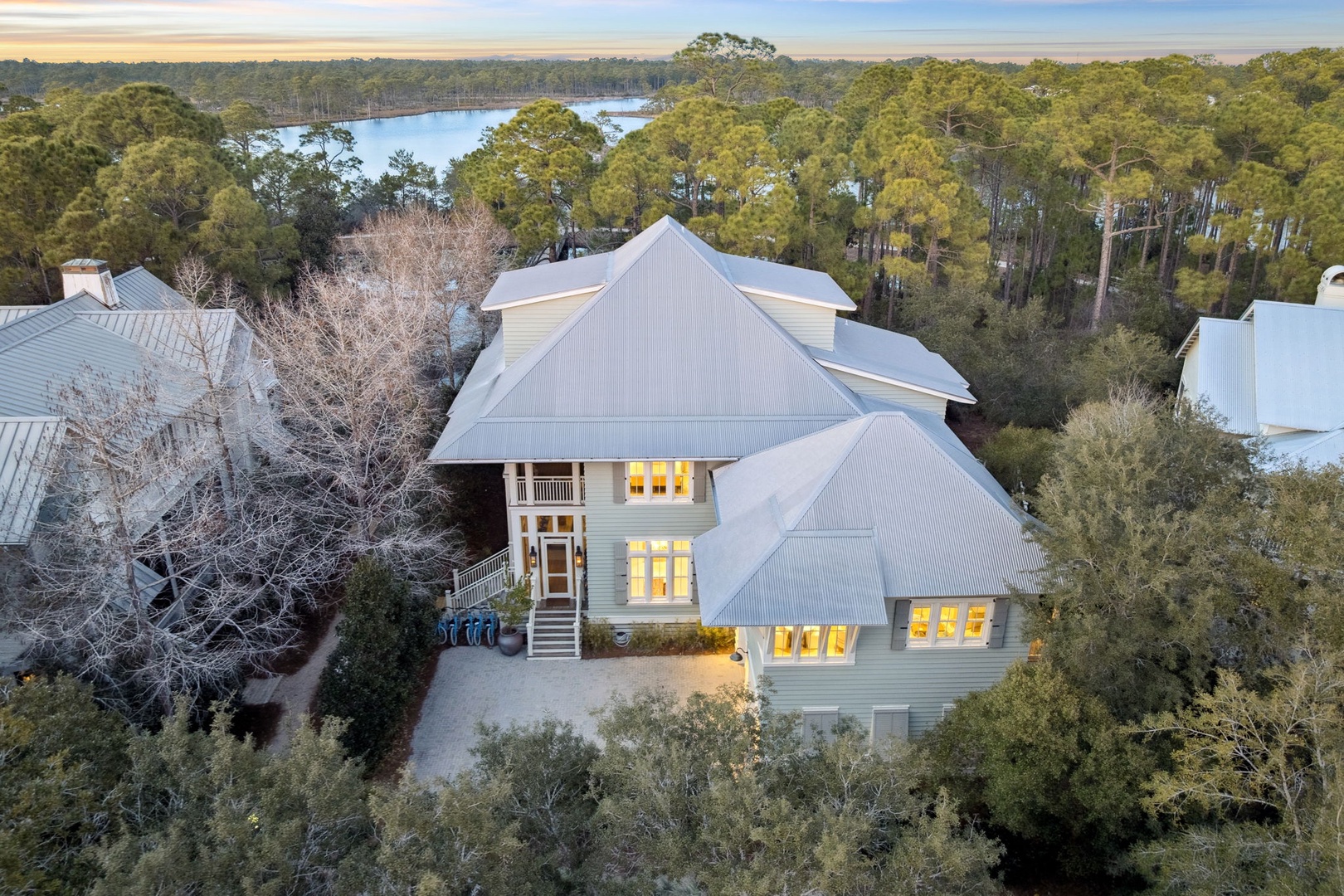 Stunning coastal home nestled among towering pines with serene lake views stretching to the horizon.
