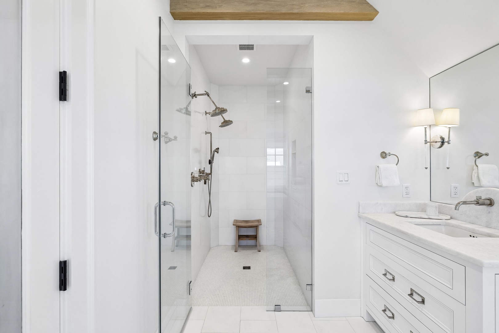 Step into your bright spa-like bathroom with a spacious walk-in shower, dual vanity, and warm wooden accents that invite total relaxation after your daily adventures.