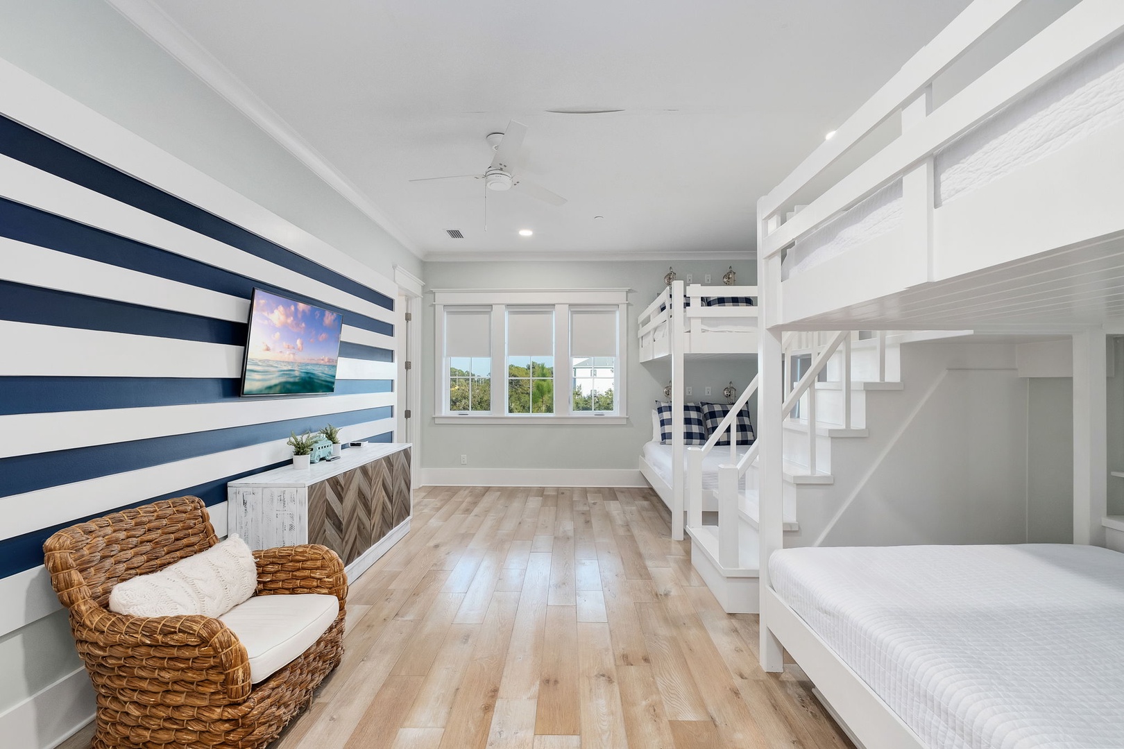Your coastal retreat features nautical stripes, bunk beds, and wicker seating for ultimate beachside comfort.