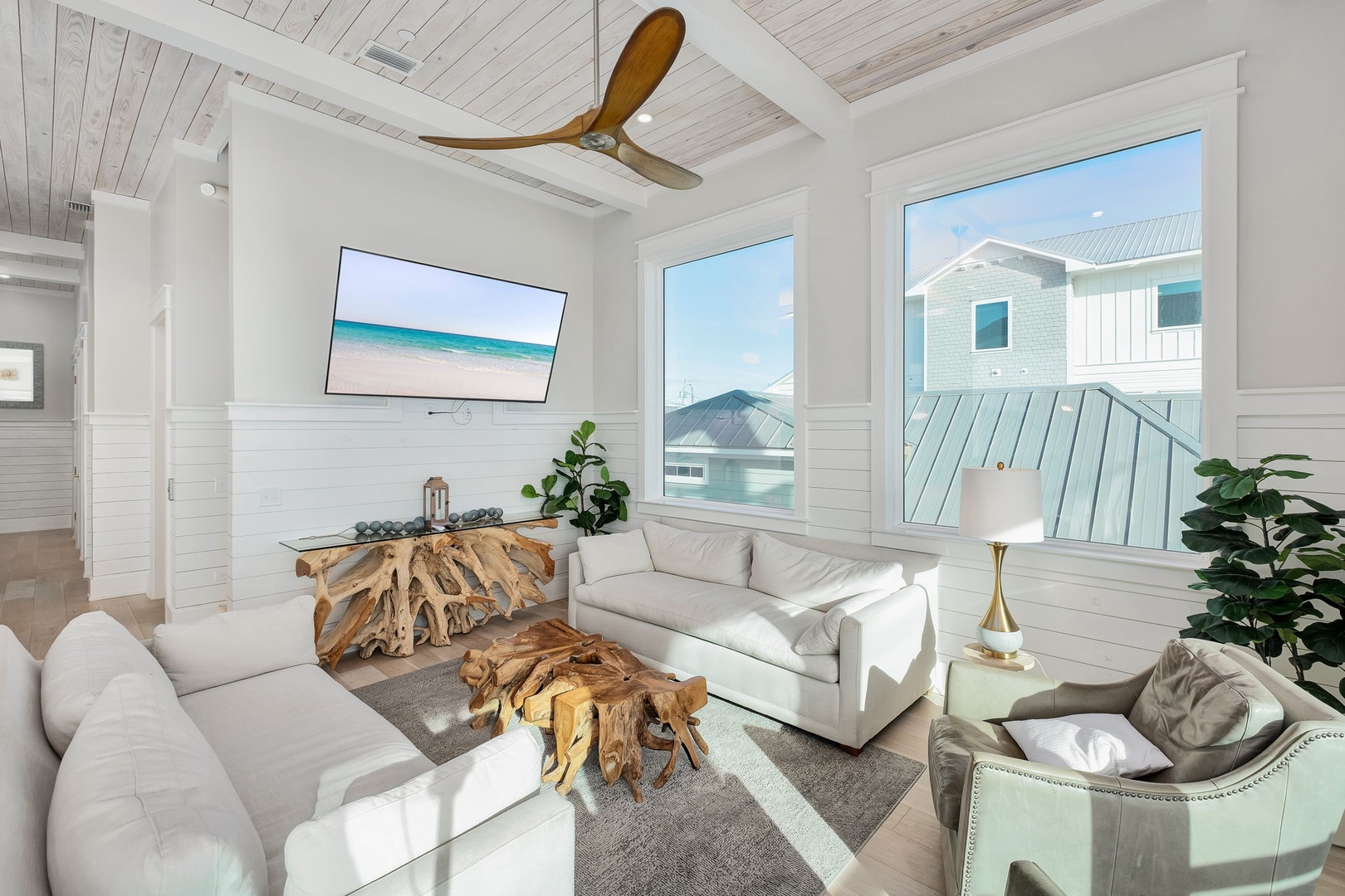 Sink into plush white sofas while gentle ocean breezes from your ceiling fan cool this elegant living space.