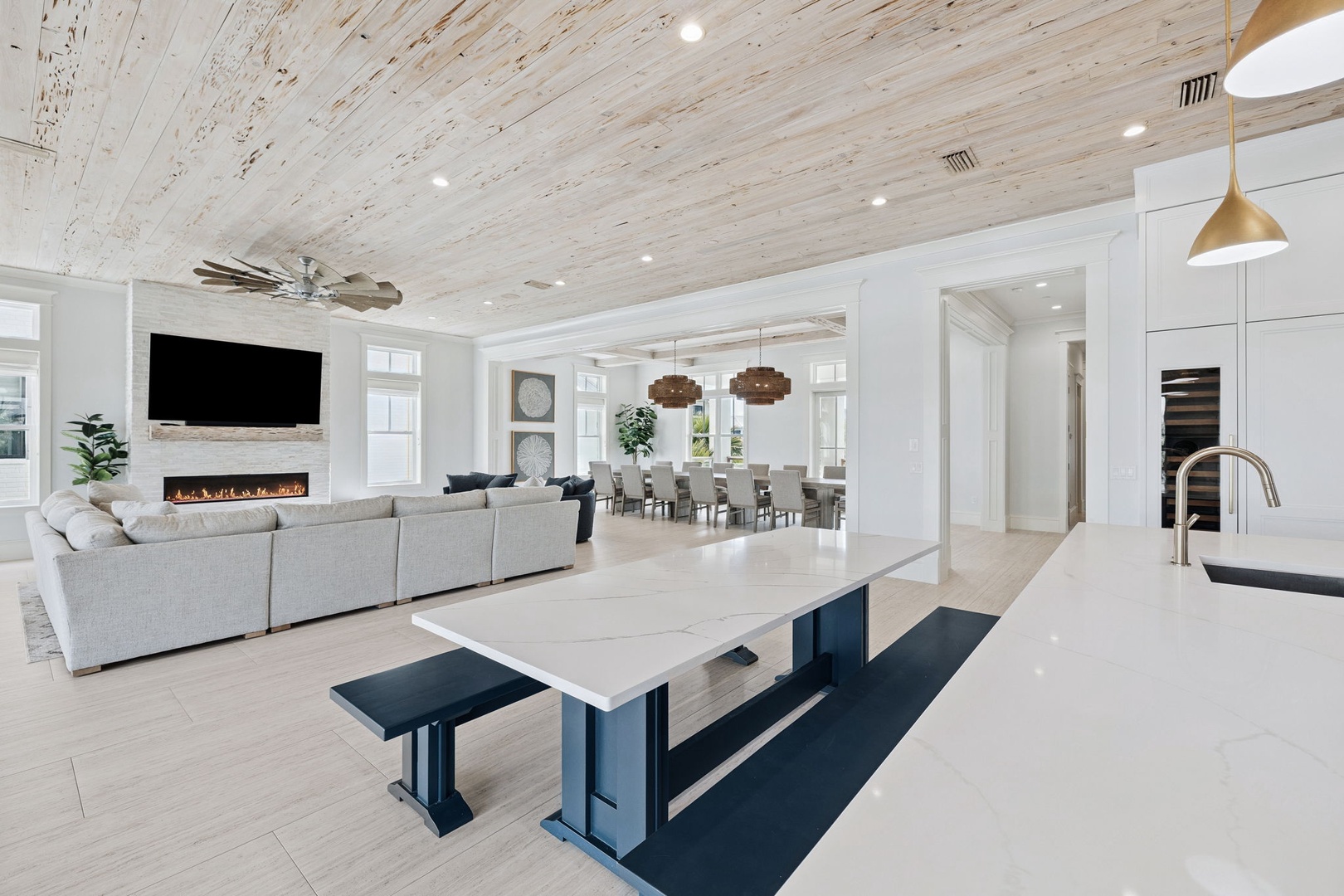 Unwind in your spacious open-concept living area with soaring wood ceilings, cozy fireplace, and modern kitchen island perfect for gathering.