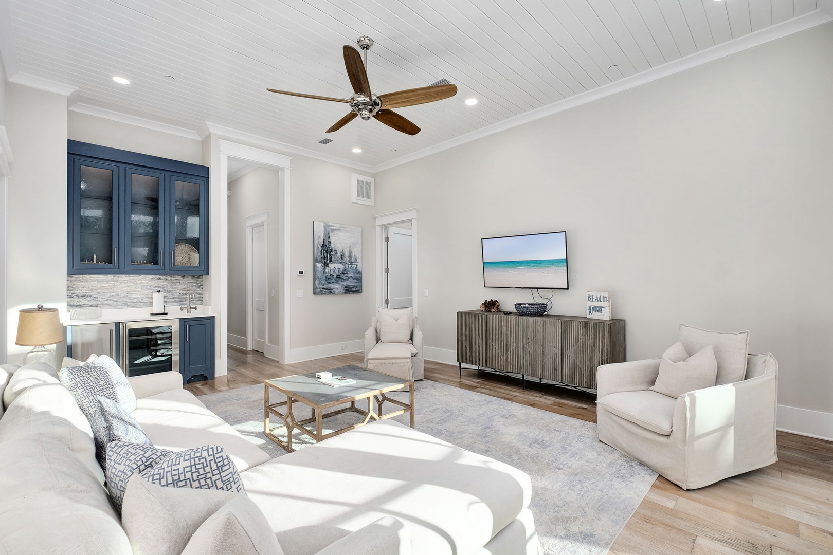 Relax in your stylish living space with plush seating, ocean-inspired artwork, and coastal elegance throughout.