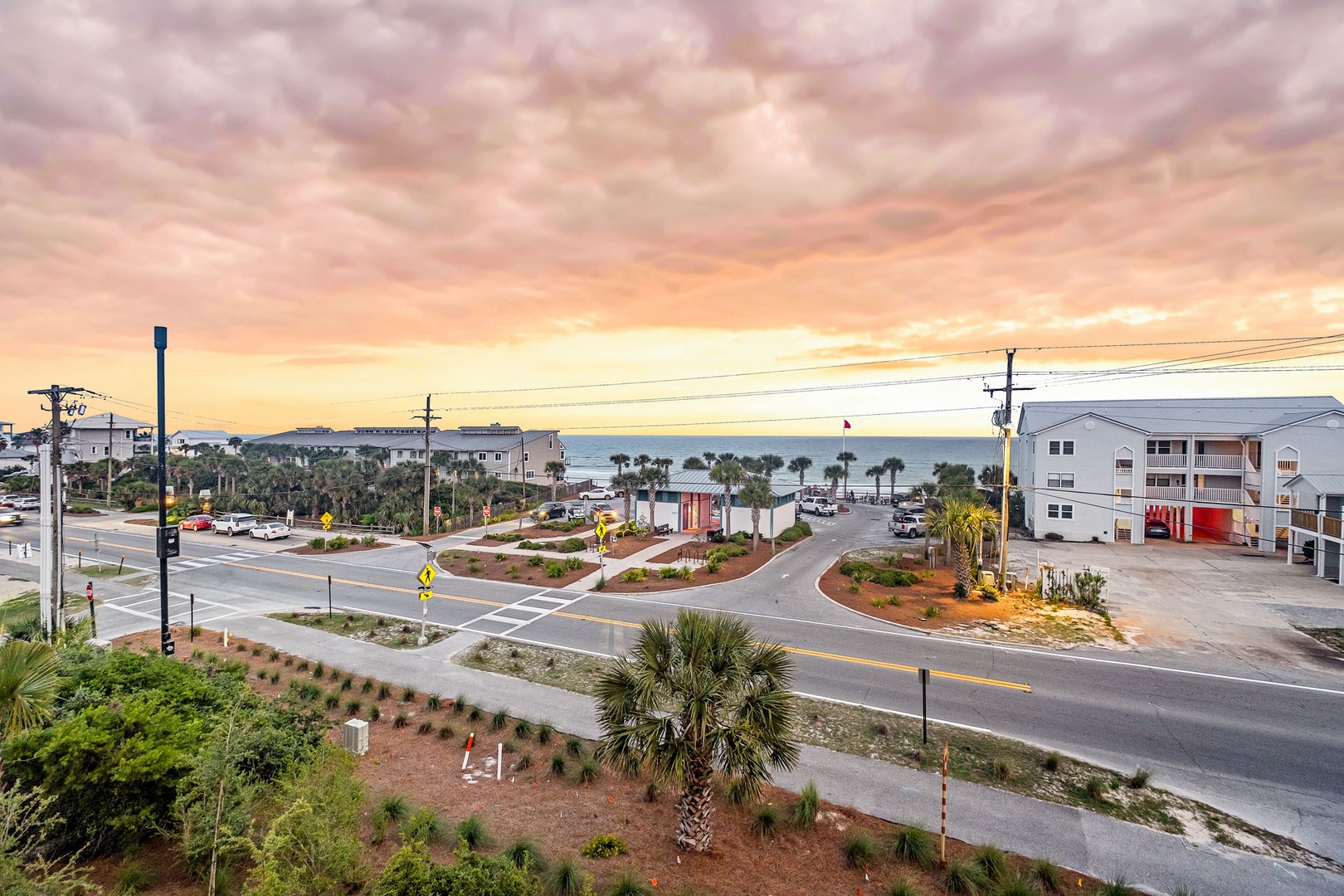 Coastal neighborhood with palm-lined streets leading to beach access, capturing the serene atmosphere of a seaside community at golden hour.