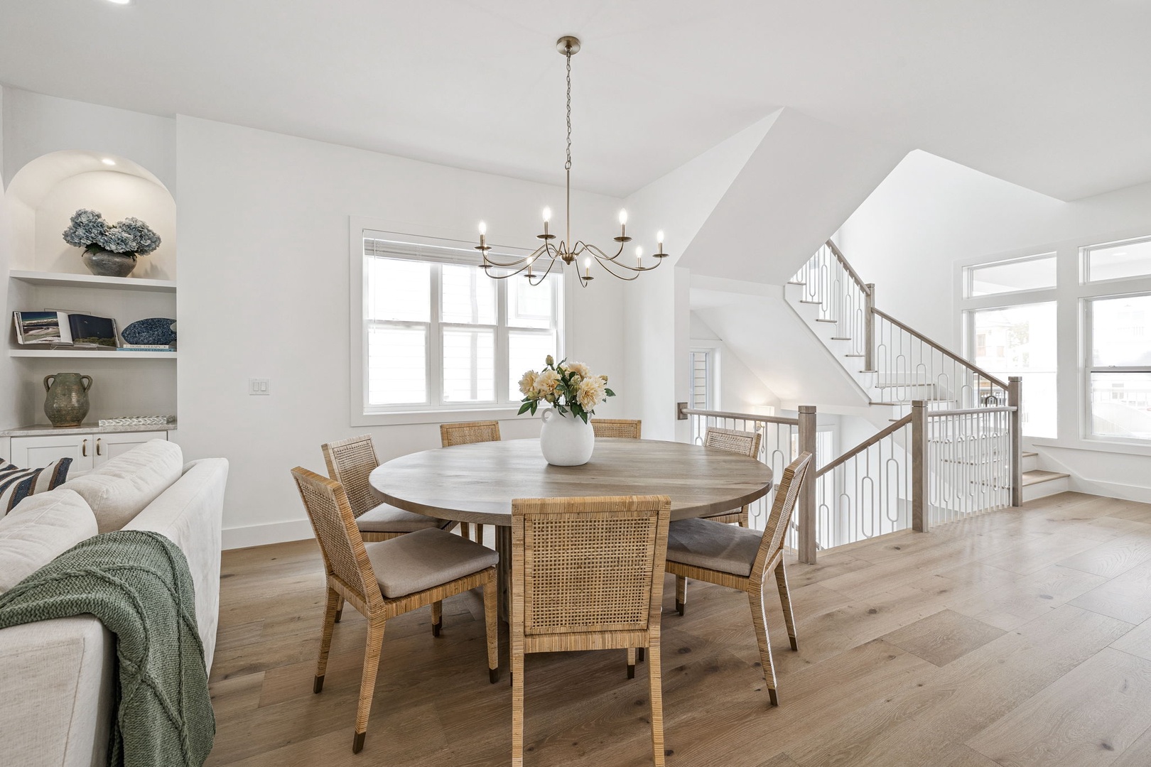 Gather around your elegant dining table where warm wood meets coastal charm, perfect for memorable meals with loved ones.