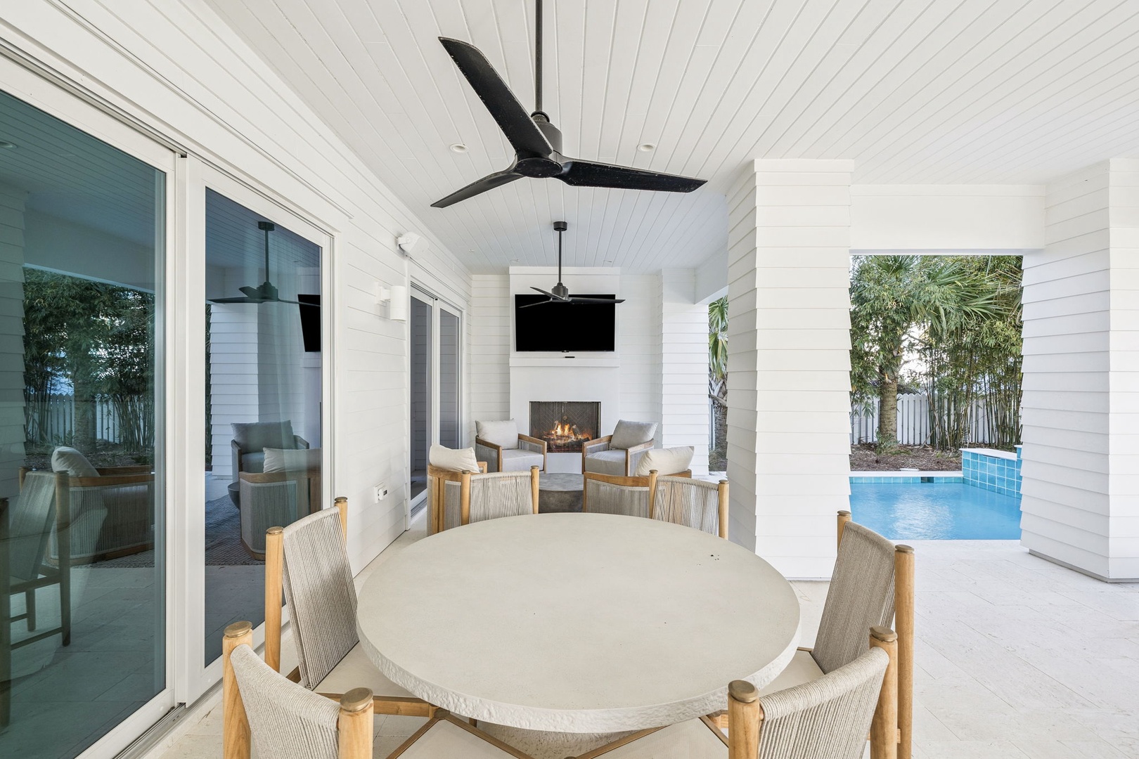 Unwind on your private covered terrace with pool views, where outdoor dining meets cozy fireplace evenings.