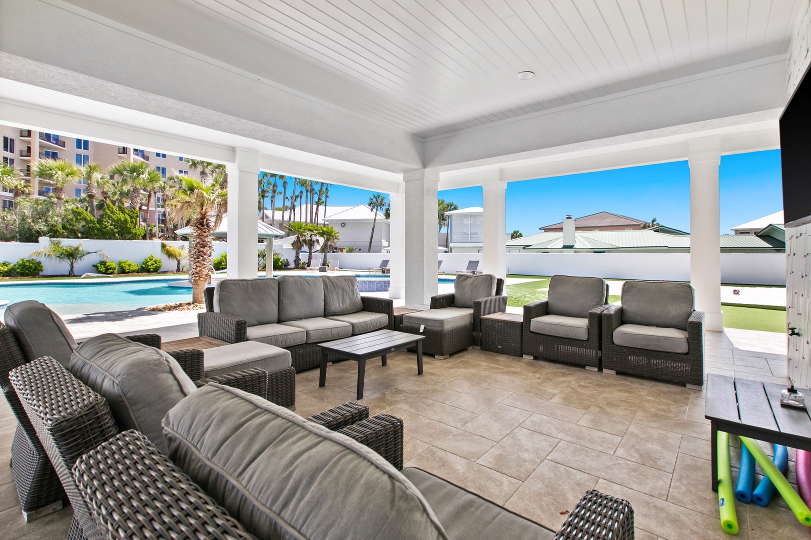 Unwind in your covered poolside lounge, where plush outdoor seating invites you to relax while palm trees sway and sparkling water beckons just steps away.