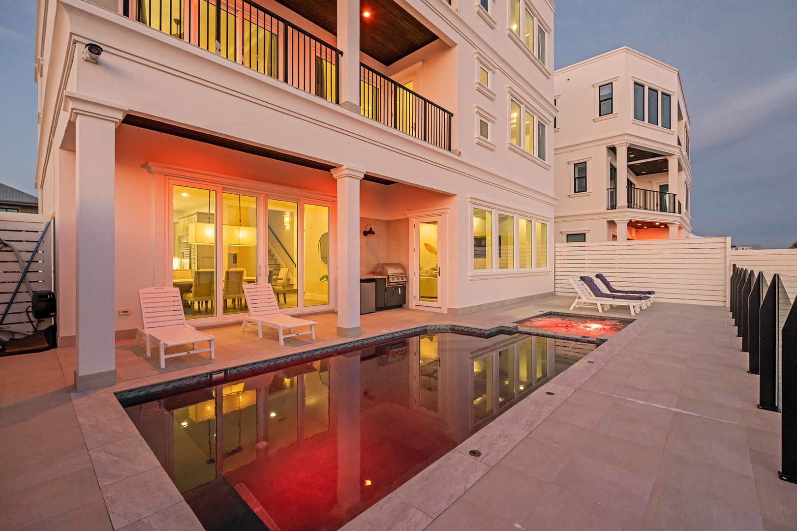 Elegant beachfront property with pool at twilight, perfectly positioned for luxury coastal stays.