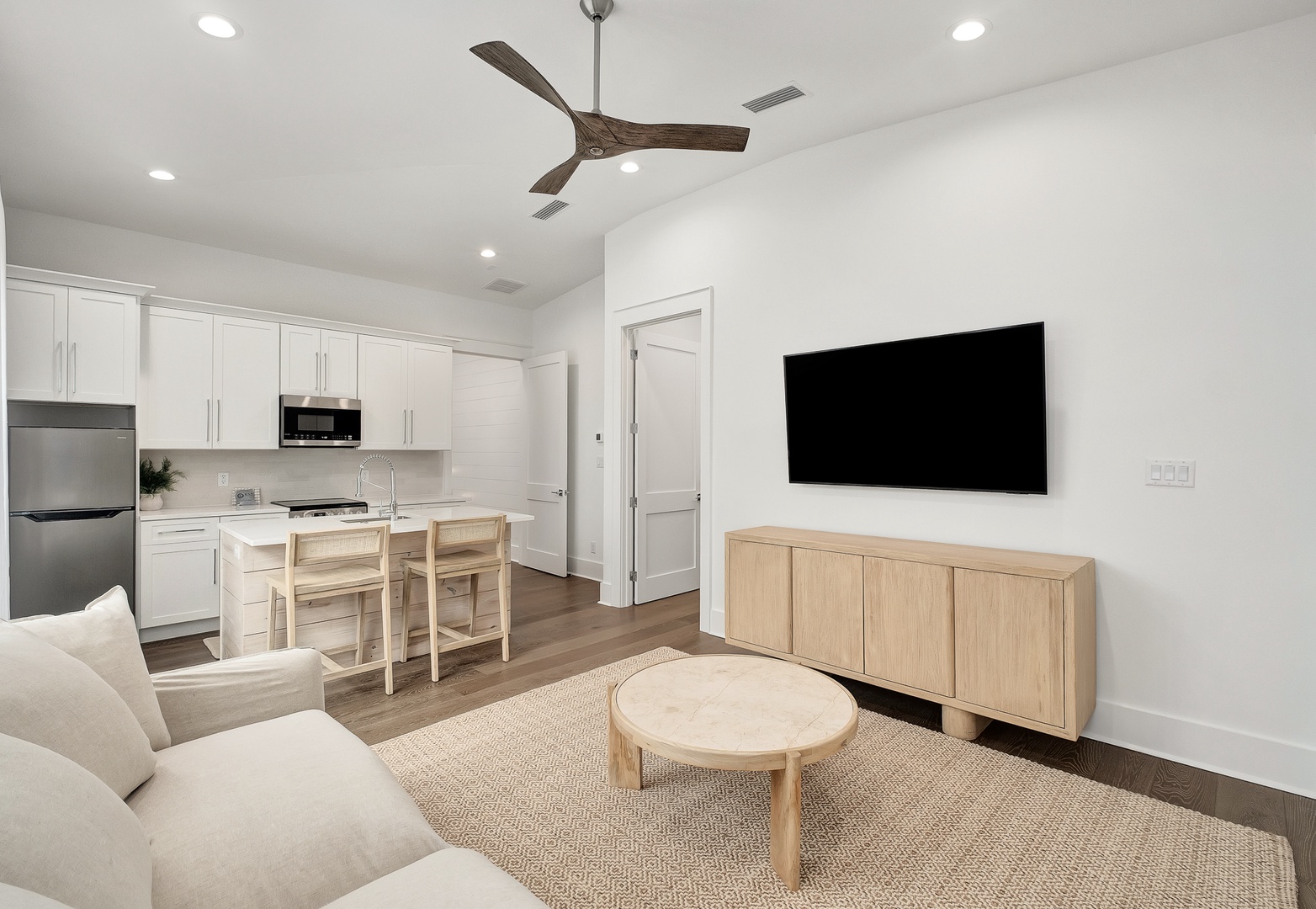Your bright, modern retreat combines kitchen and living areas perfectly. Relax on plush seating while enjoying the large TV and natural wood accents.