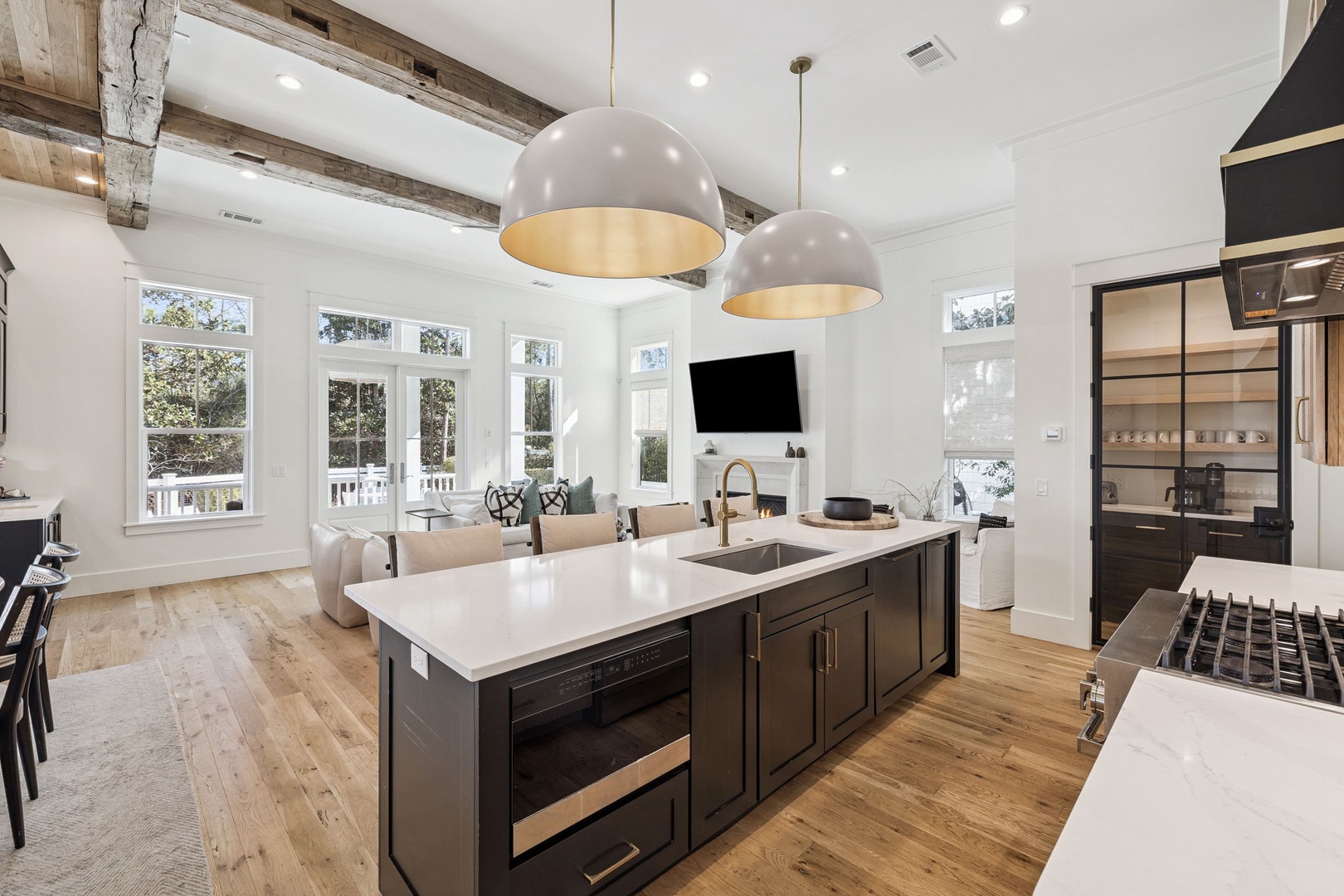 You'll love this stunning open-concept kitchen with soaring ceilings, rustic beams, and golden pendant lights creating the perfect gathering space.