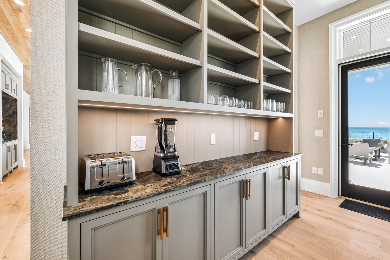 Your morning coffee station awaits—bright, organized, and steps from the ocean. Grab a fresh cup and step out to feel the coastal breeze through the nearby doorway.