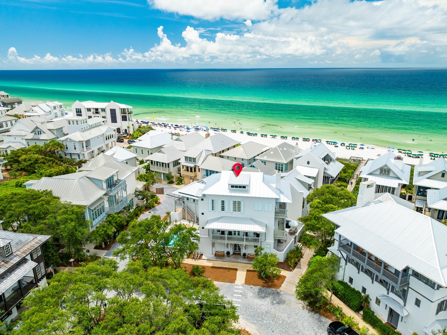 Stunning beachfront community with pristine emerald waters and white sand beaches just steps away from charming coastal homes.