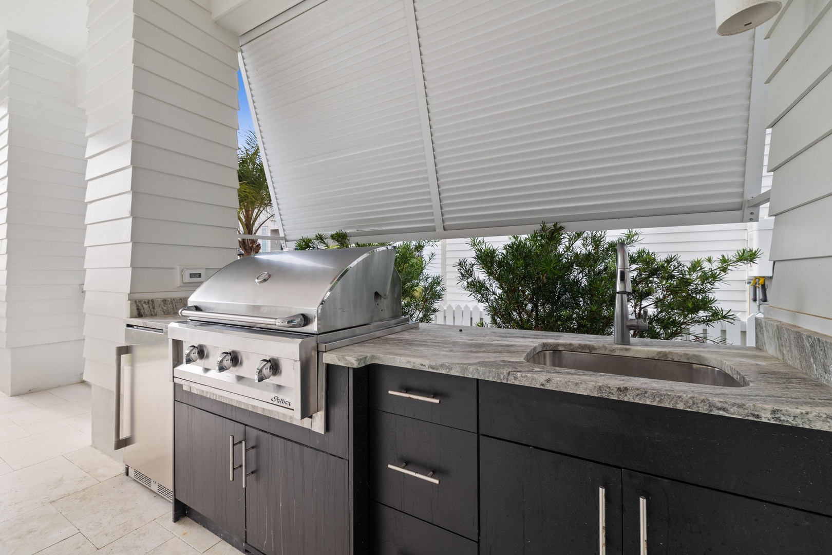 Your private outdoor kitchen awaits with premium grill and granite prep space for memorable meals.