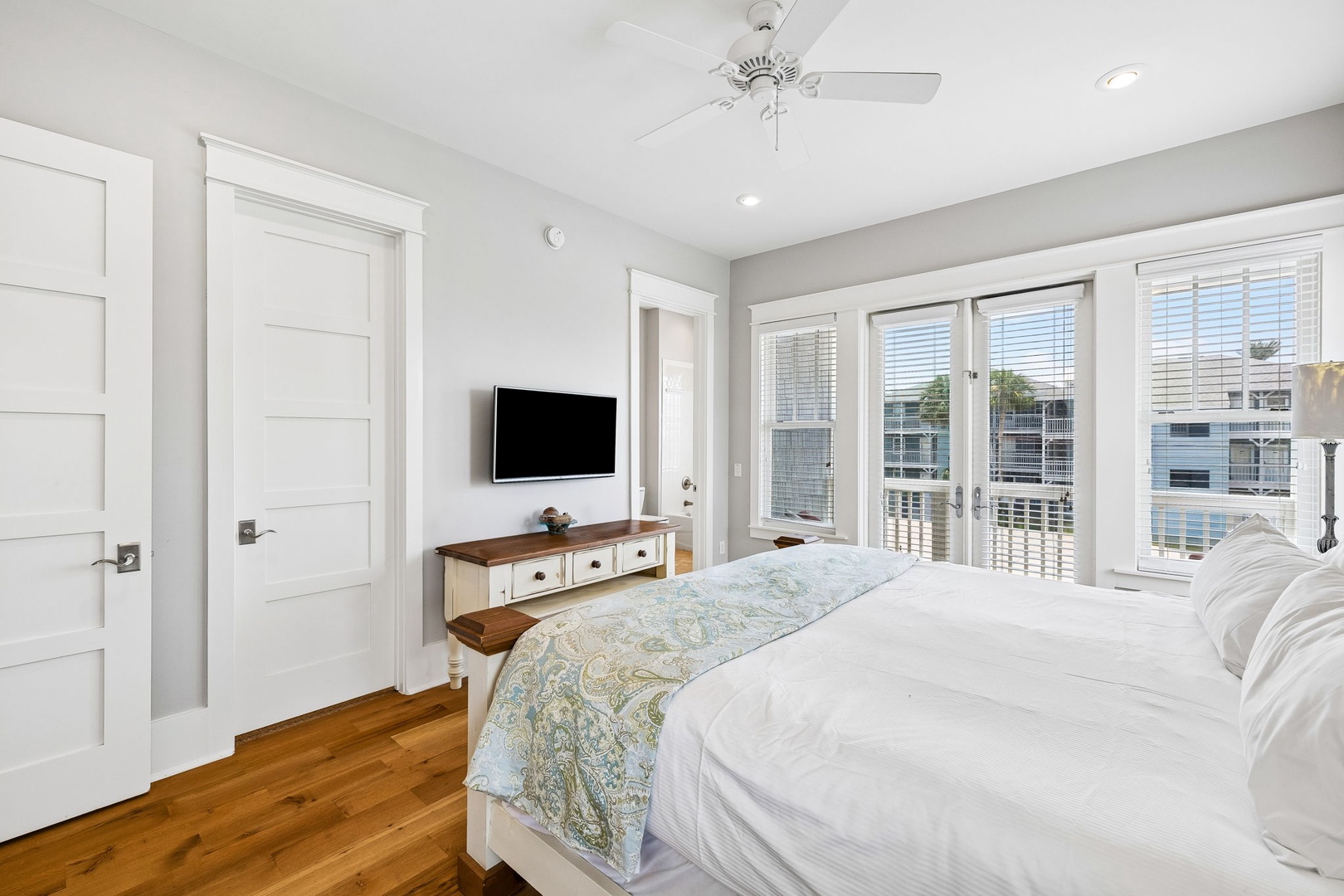 Wake up in your peaceful retreat with warm wood floors, crisp white linens, and gentle light streaming through expansive windows. Your private balcony awaits, perfect for morning coffee or evening relaxation.