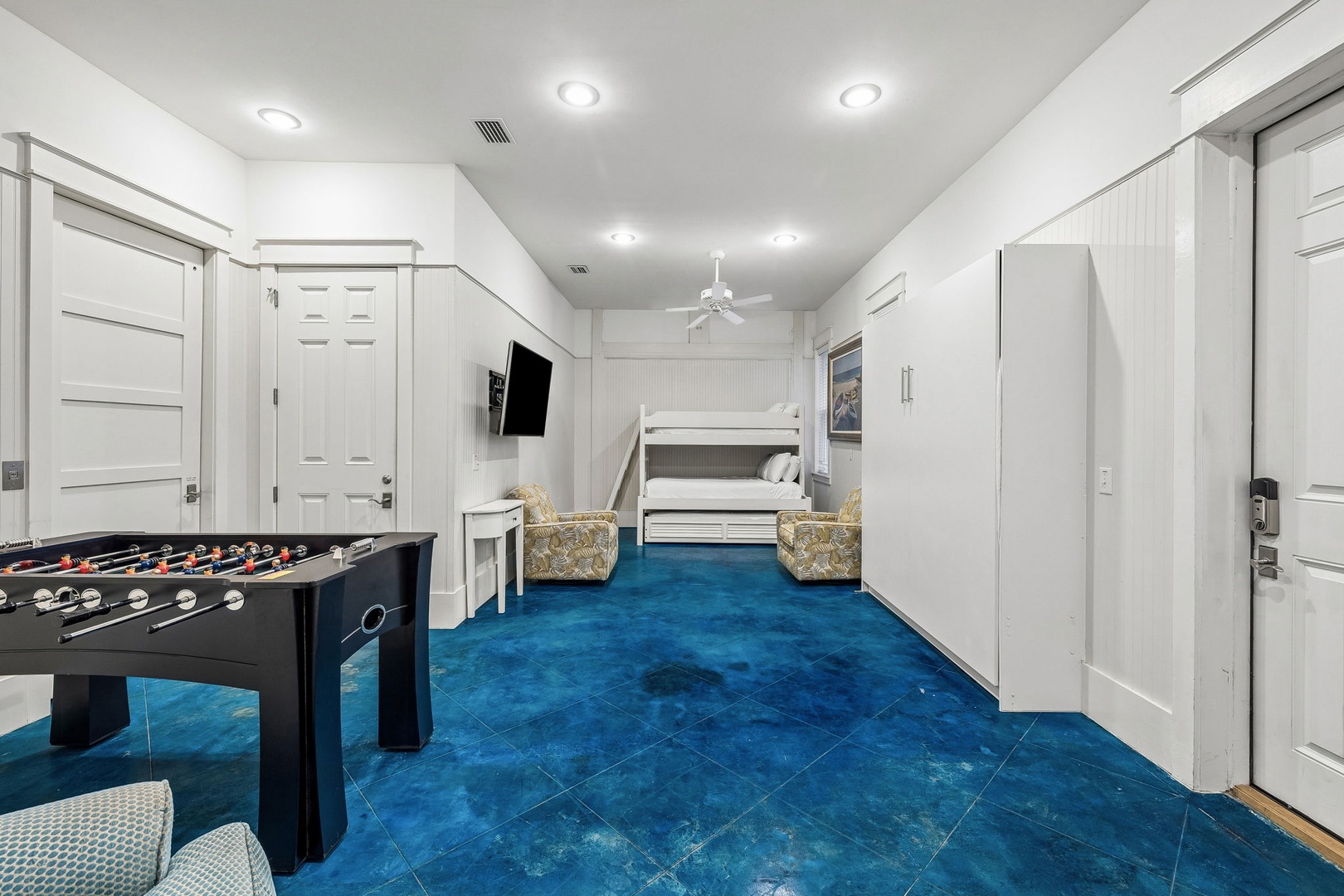 Your private retreat features a foosball table for friendly competitions, bunk beds ready for restful nights, and plenty of storage. The bold blue floors add a playful coastal vibe to your stay.