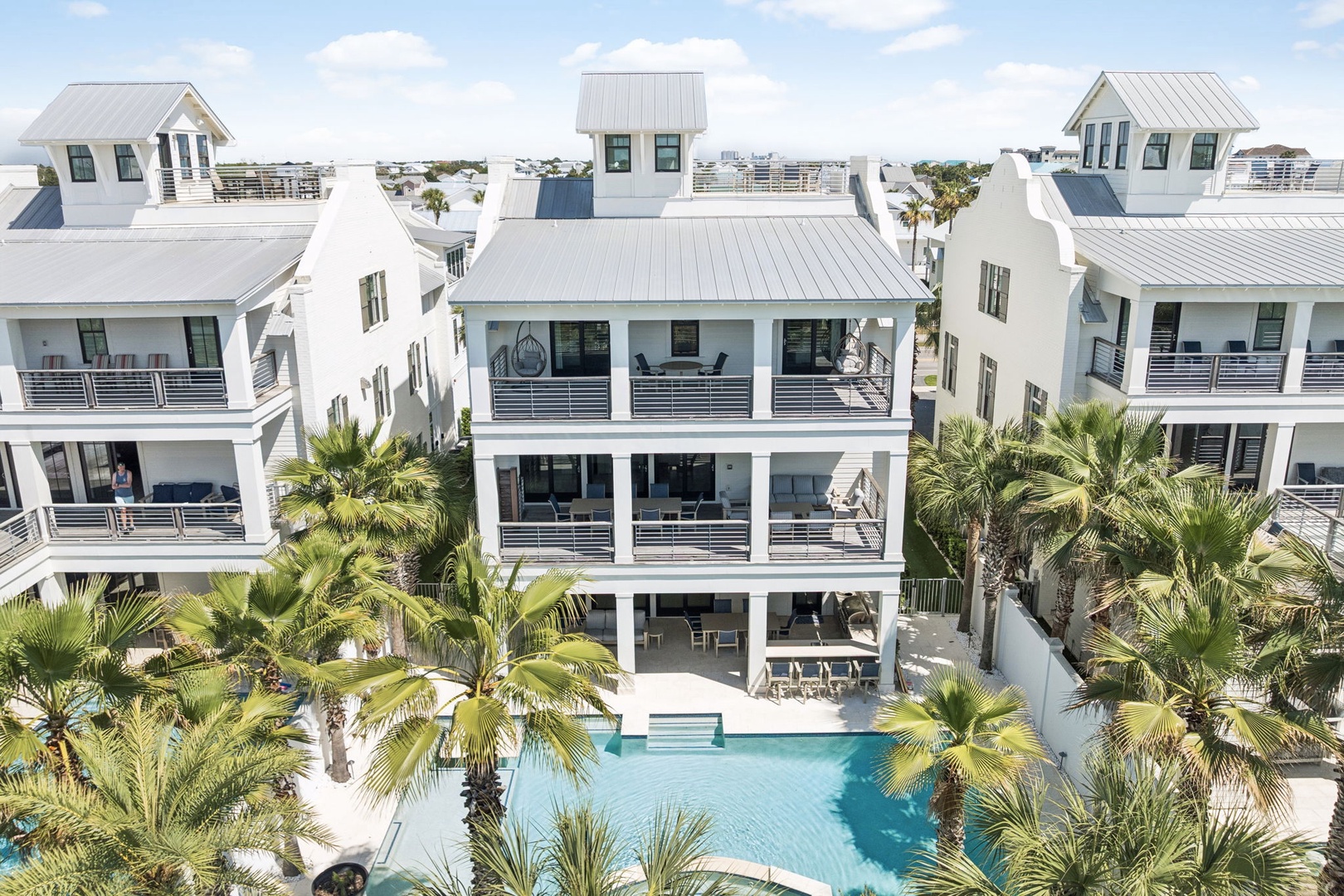 Modern beach house with private pool surrounded by tropical palms in an upscale coastal neighborhood.