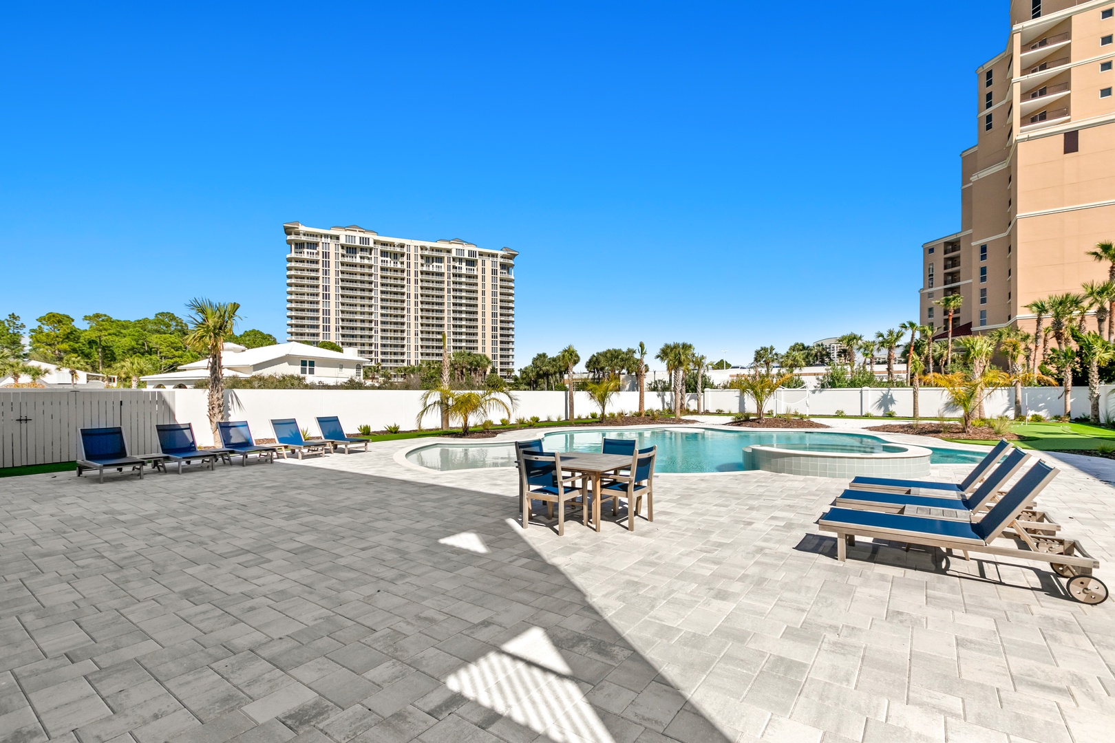Soak up the sunshine on your private pool deck, complete with inviting lounge chairs and a sparkling pool surrounded by swaying palms—your perfect spot to unwind.