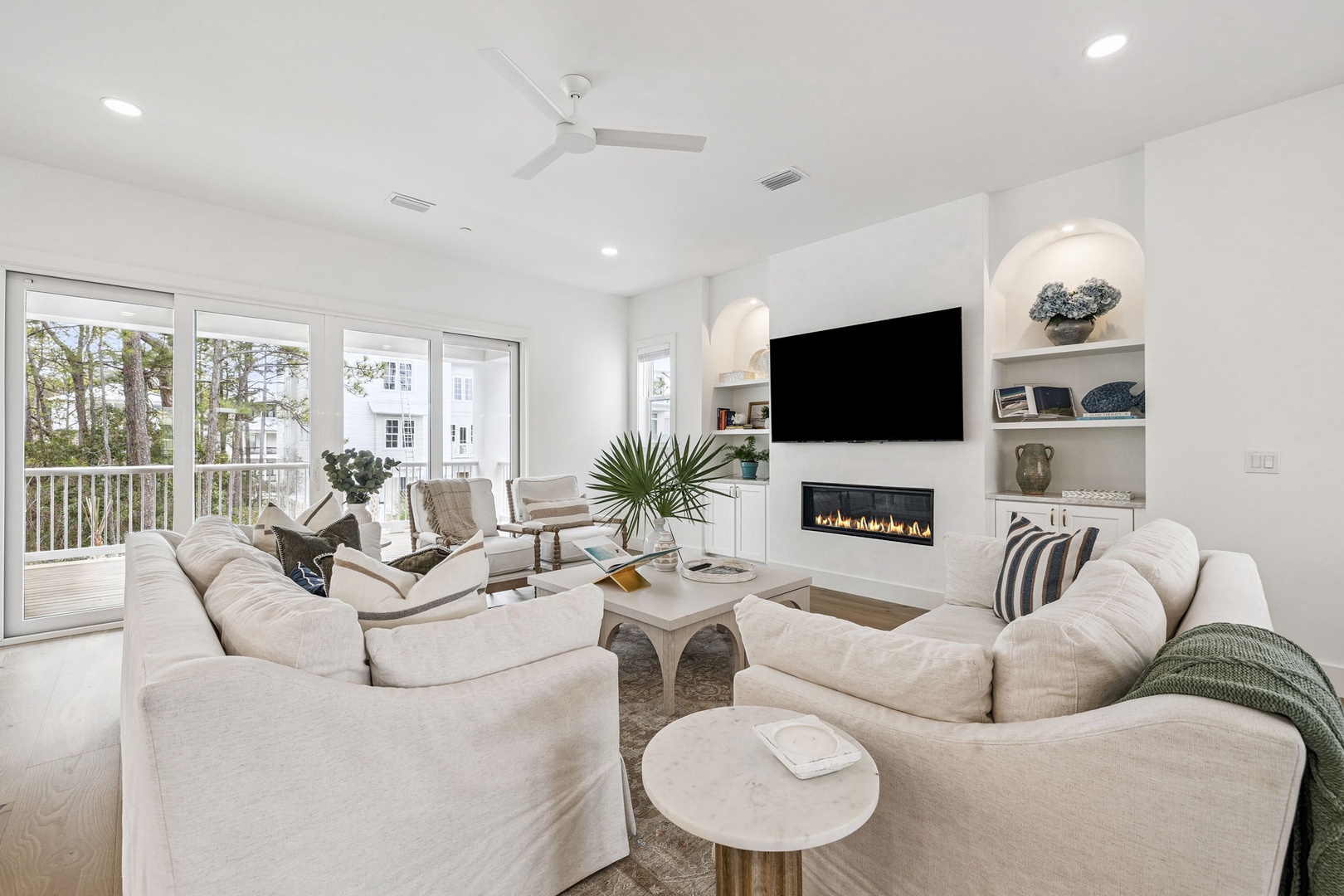 Sink into plush seating while your fireplace crackles and natural light streams through floor-to-ceiling windows in this elegant living space.