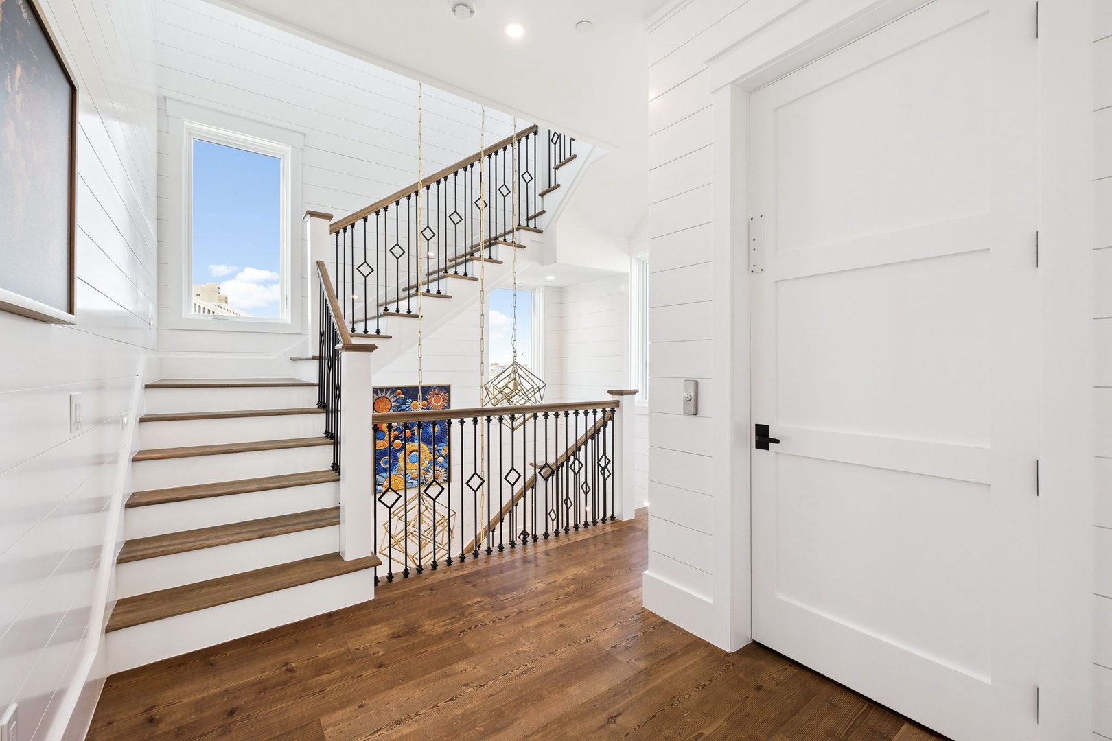 Discover your bright, airy entryway with stunning shiplap walls and elegant staircase that welcomes you home with warmth and coastal charm.